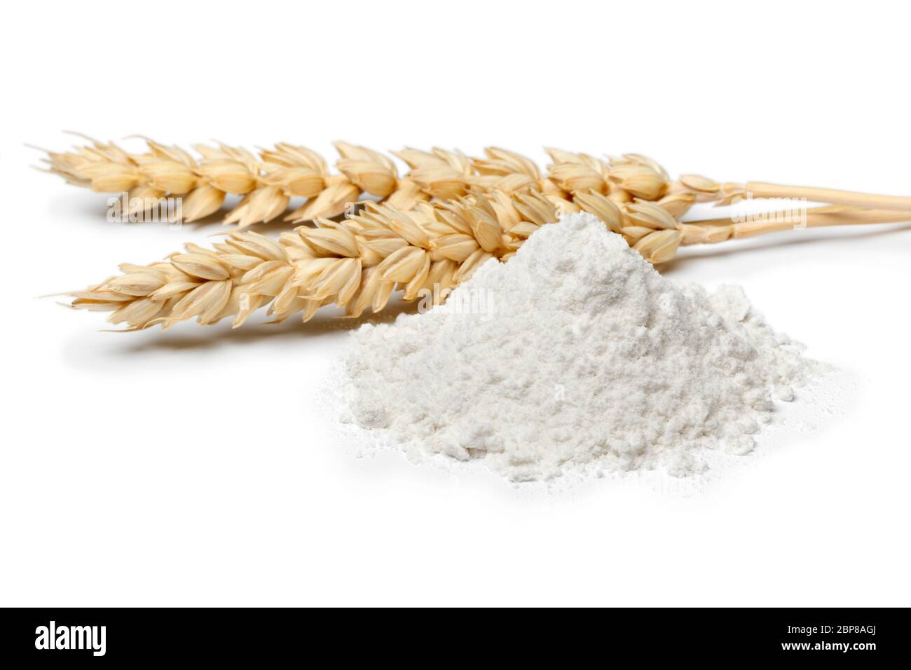 Cumulo di farina bianca di grano da vicino e spighe di grano isolate su sfondo bianco Foto Stock
