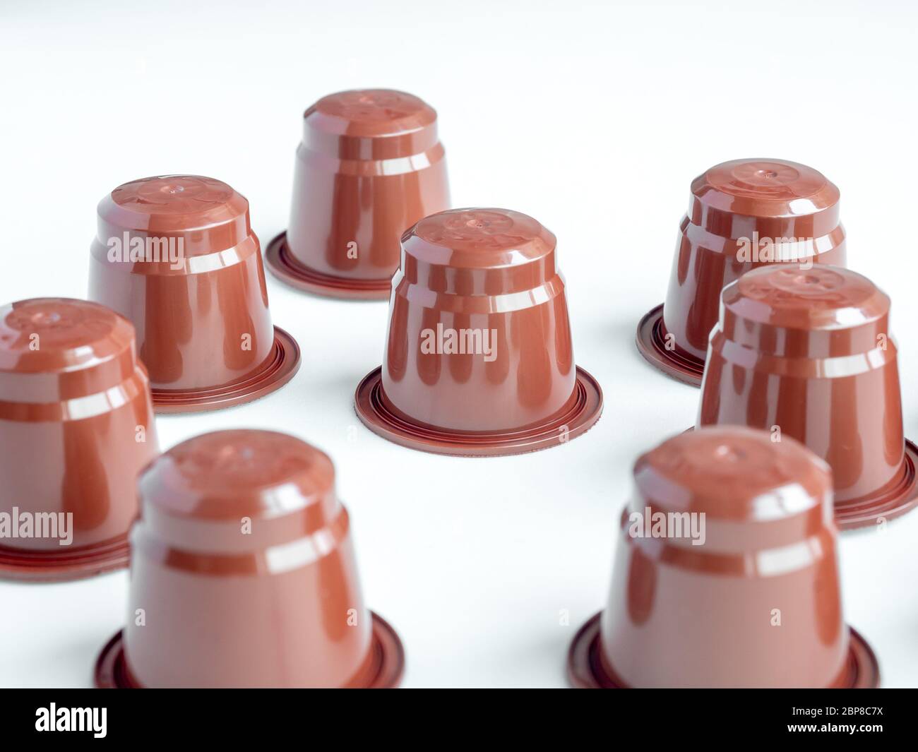 Primo piano su capsule di caffè marrone espresso su sfondo bianco. Foto Stock
