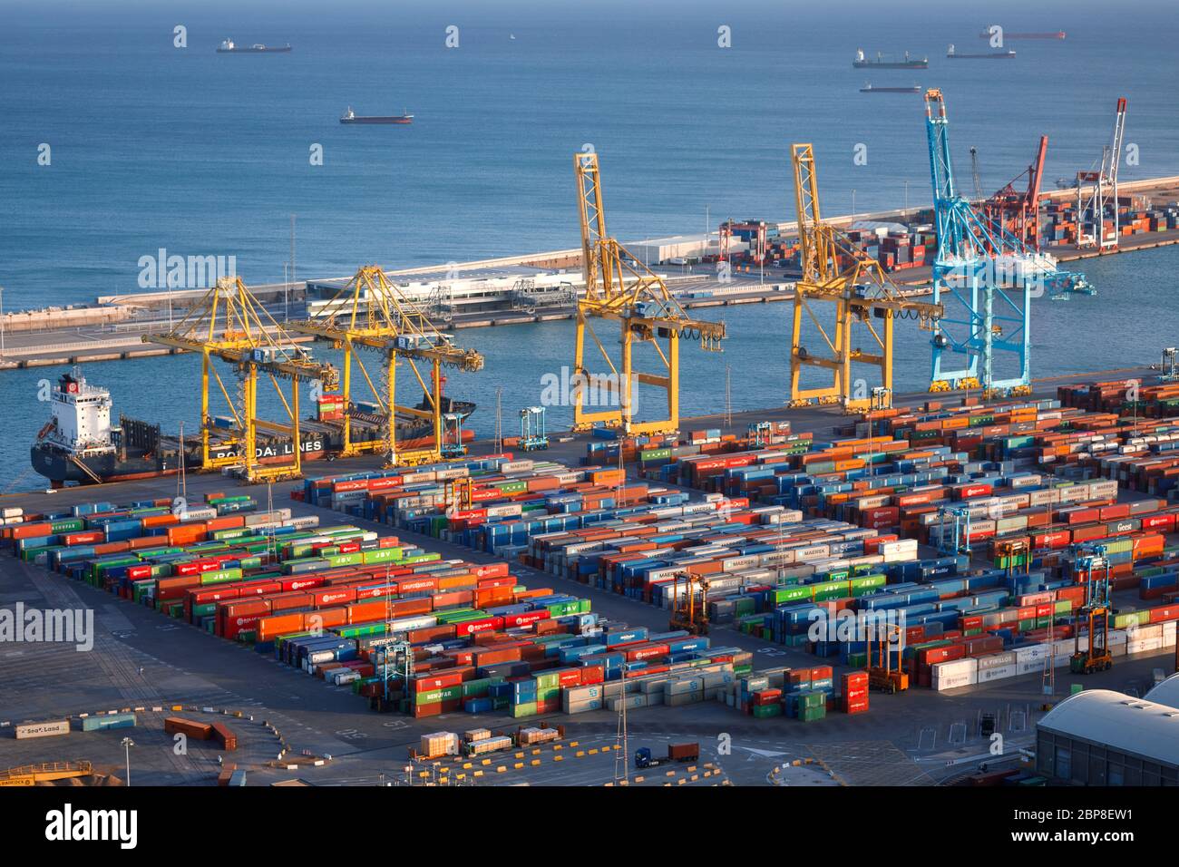 Barcellona, Spagna - 02. 27. 2020 - porto con contenitori colorati, gru e mare Foto Stock