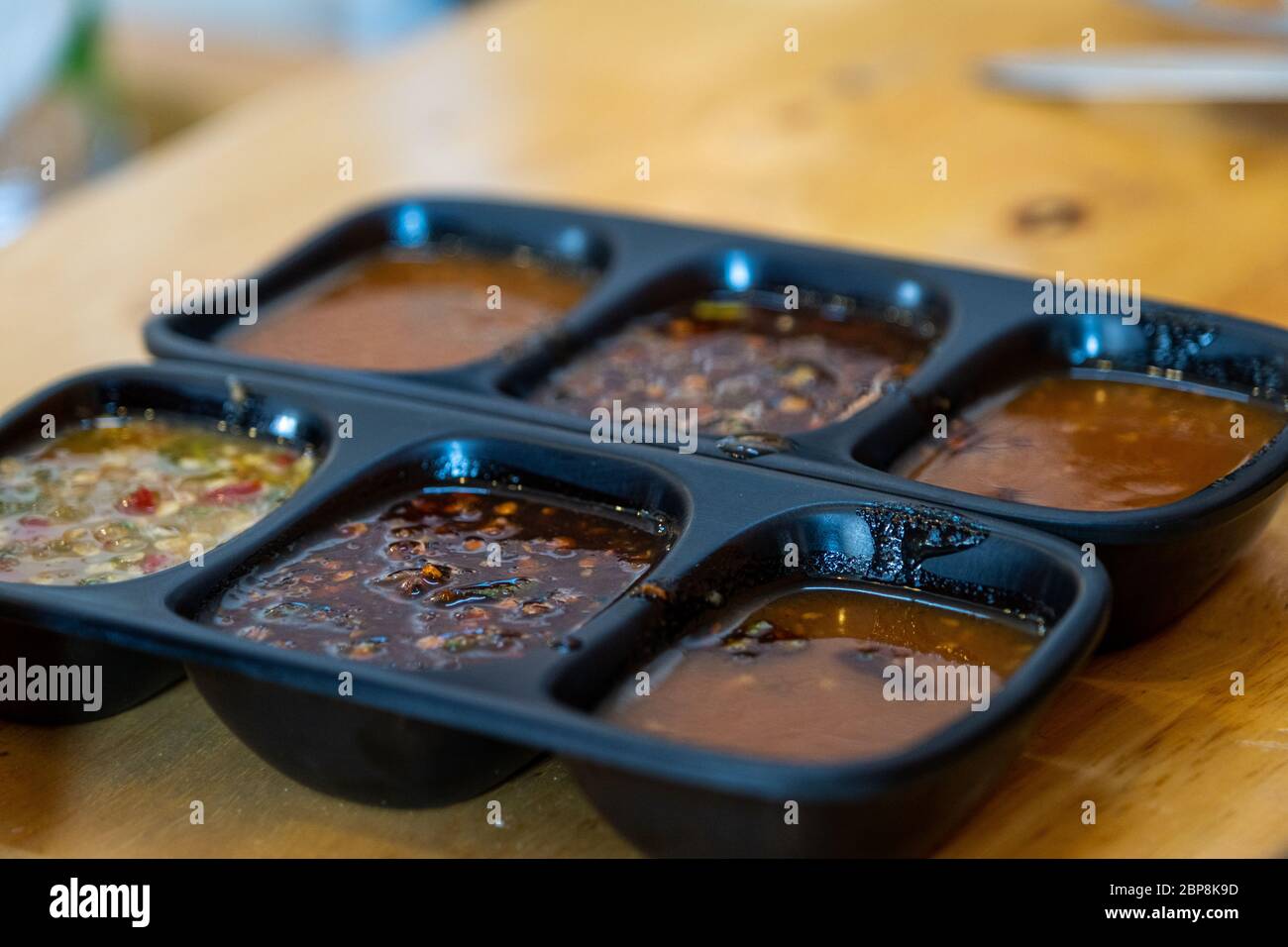 Le salse piccanti e condimenti per Shabu in tazza di salsa su un tavolo di legno background.immersione salsa per shabu. Foto Stock