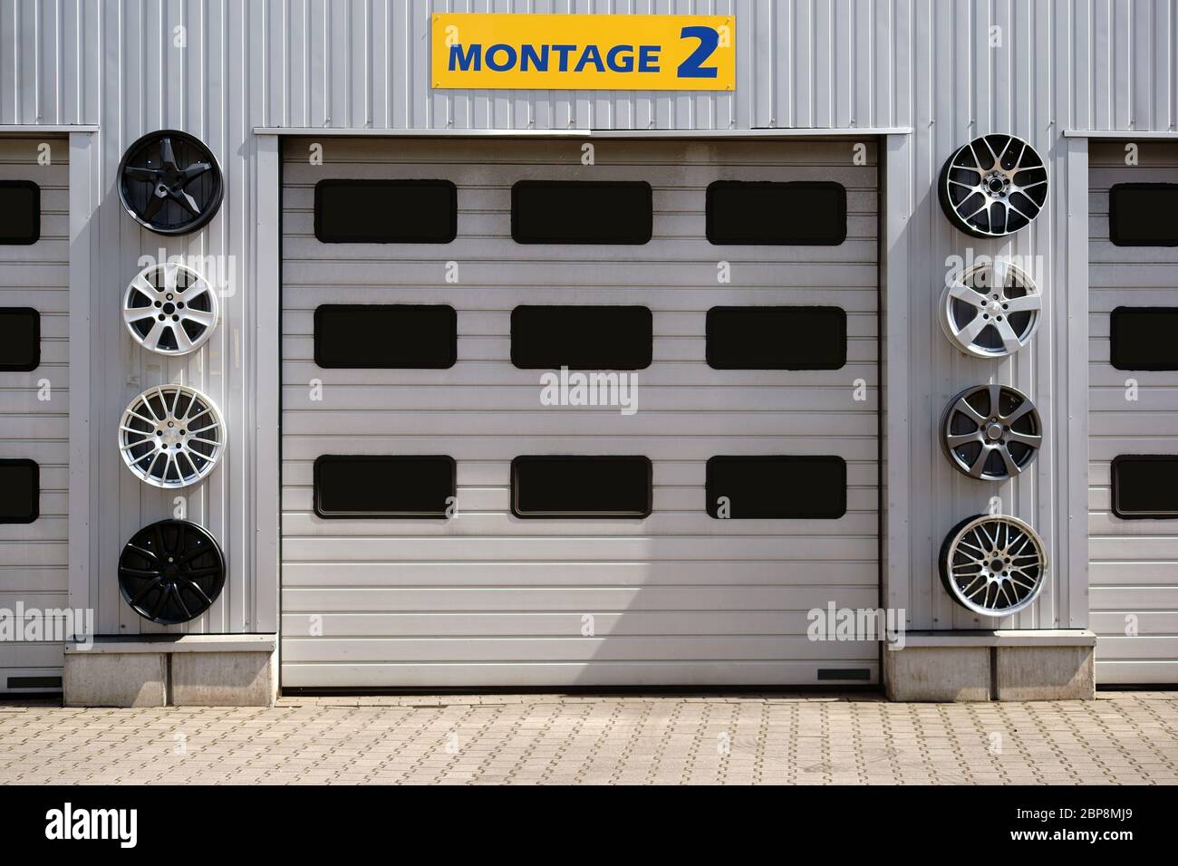 Eine Autowerkstatt mit mehreren Garagen und Sportfelgen zur Dekoration. Foto Stock
