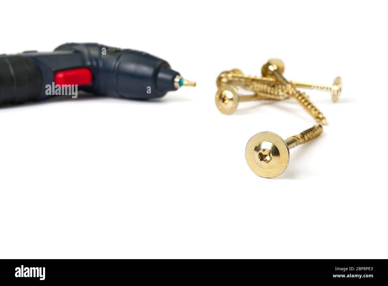viti torx in zinco giallo e cacciavite elettrico, isolate su bianco. viti per punta a stella. Foto Stock