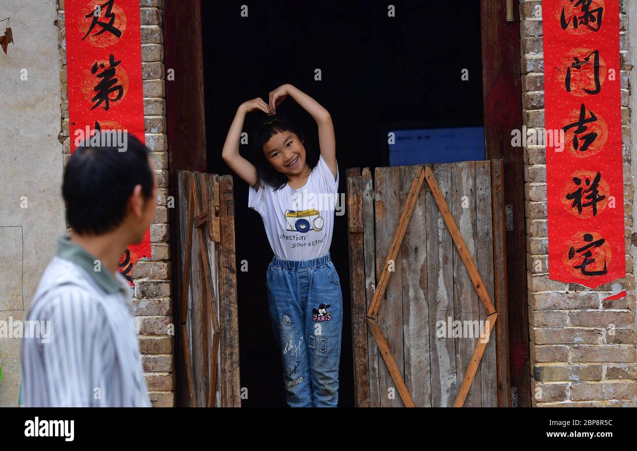 (200518) -- PECHINO, 18 maggio 2020 (Xinhua) -- Pan Yuxin, figlia di Pan Wenming, gesti al padre a casa nel villaggio di Tunqiu di Pingshan Township nella contea di Luzhai, regione autonoma di Guangxi Zhuang, nella Cina meridionale, 17 aprile 2020. Dopo aver lavorato oltre dieci anni fuori dalla città natale, Pan e sua moglie tornarono a casa e mettevano il loro duro lavoro in agricoltura e zootecnia, tra cui allevare capre e polli e piantare agrumi su diverse colline. Negli ultimi anni, l’economia rurale locale si è sviluppata rapidamente e il reddito familiare è aumentato costantemente. Più di 93 milioni di persone rurali in CH Foto Stock