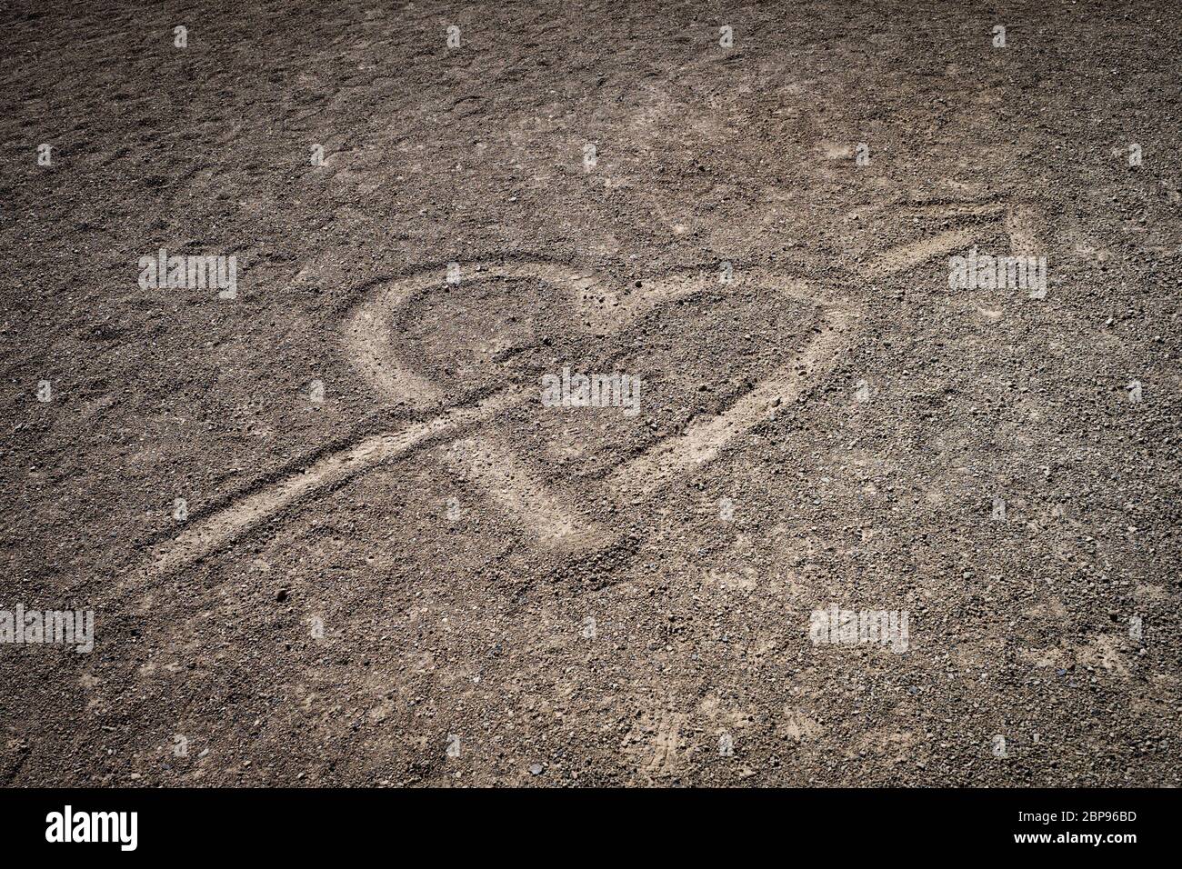 Cuore trafitto con la freccia disegnata nel suolo di origine vulcanica dell'isola di Tenerife Foto Stock