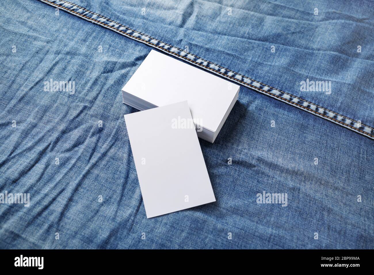 Foto di vuoto bianco schede aziendali su sfondo denim. Modello per ID. Foto Stock