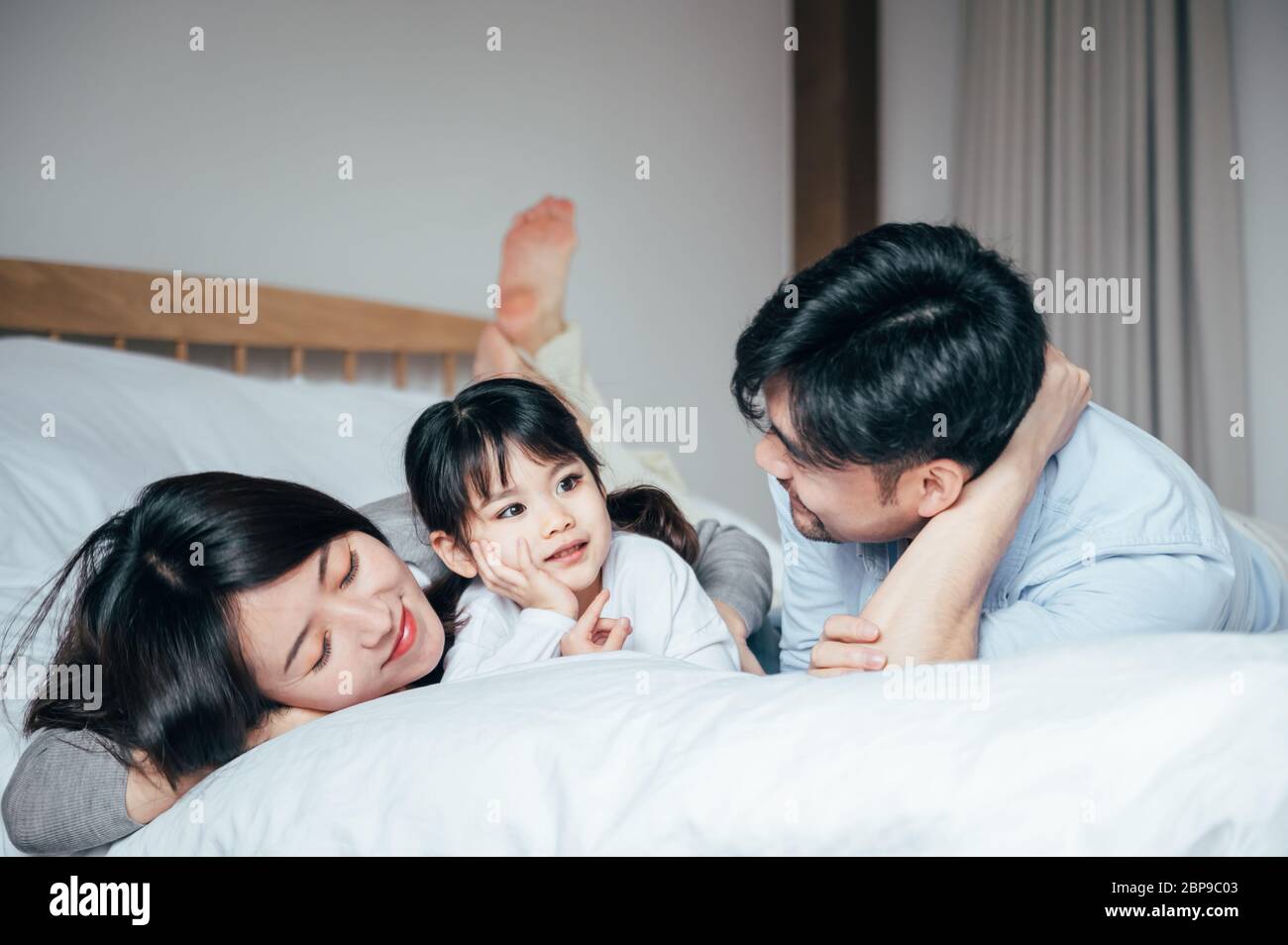 Mamma e papà e figlia in camera da letto giocando a giochi Foto stock -  Alamy