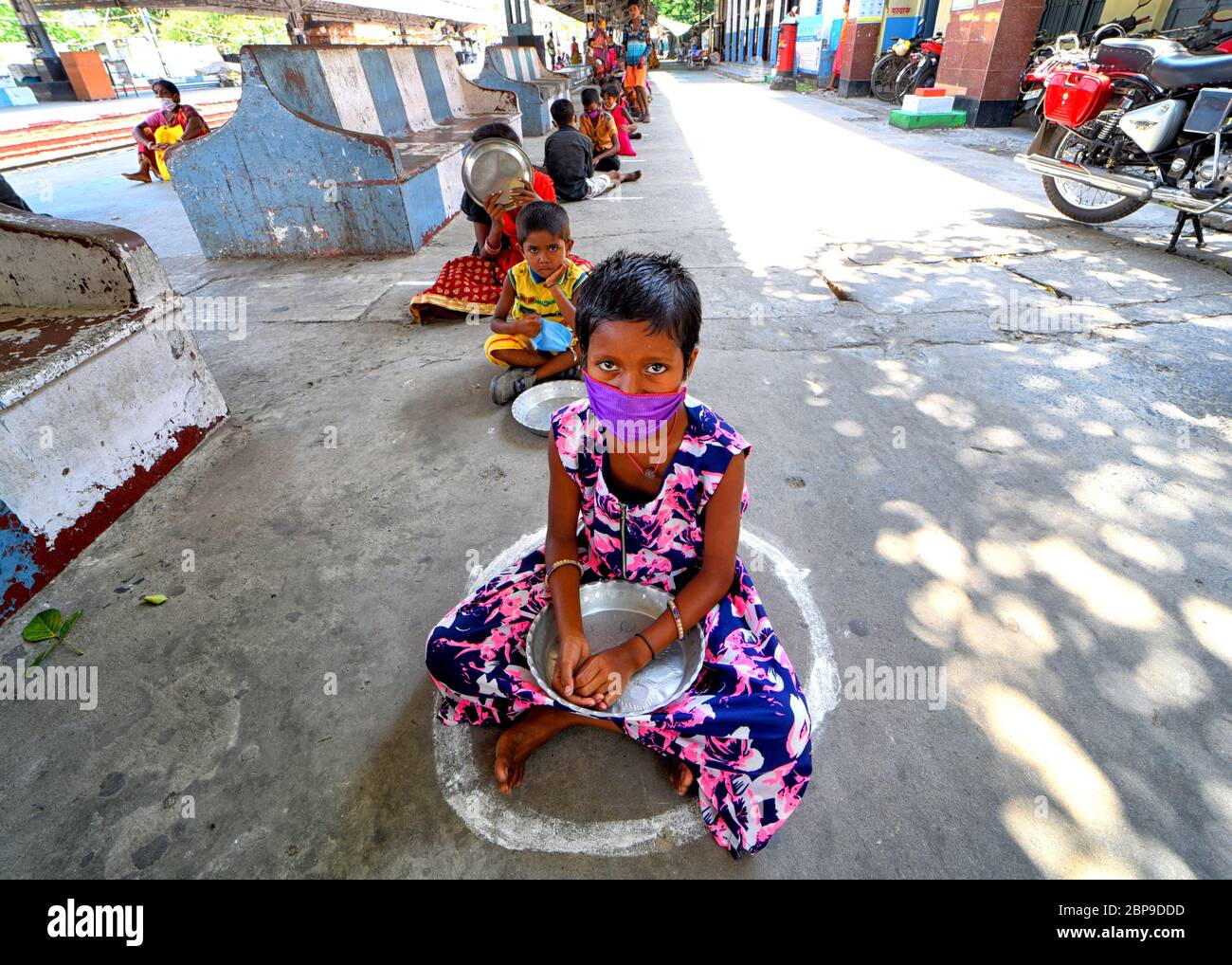 I bambini sono in fila con piatti vuoti in attesa del pranzo distribuito dagli ufficiali di polizia durante la crisi di blocco del Coronavirus (COVID-19). L'India ha finora confermato 101,156 casi di coronavirus, 3,149 morti e 36,824 recuperati. Foto Stock