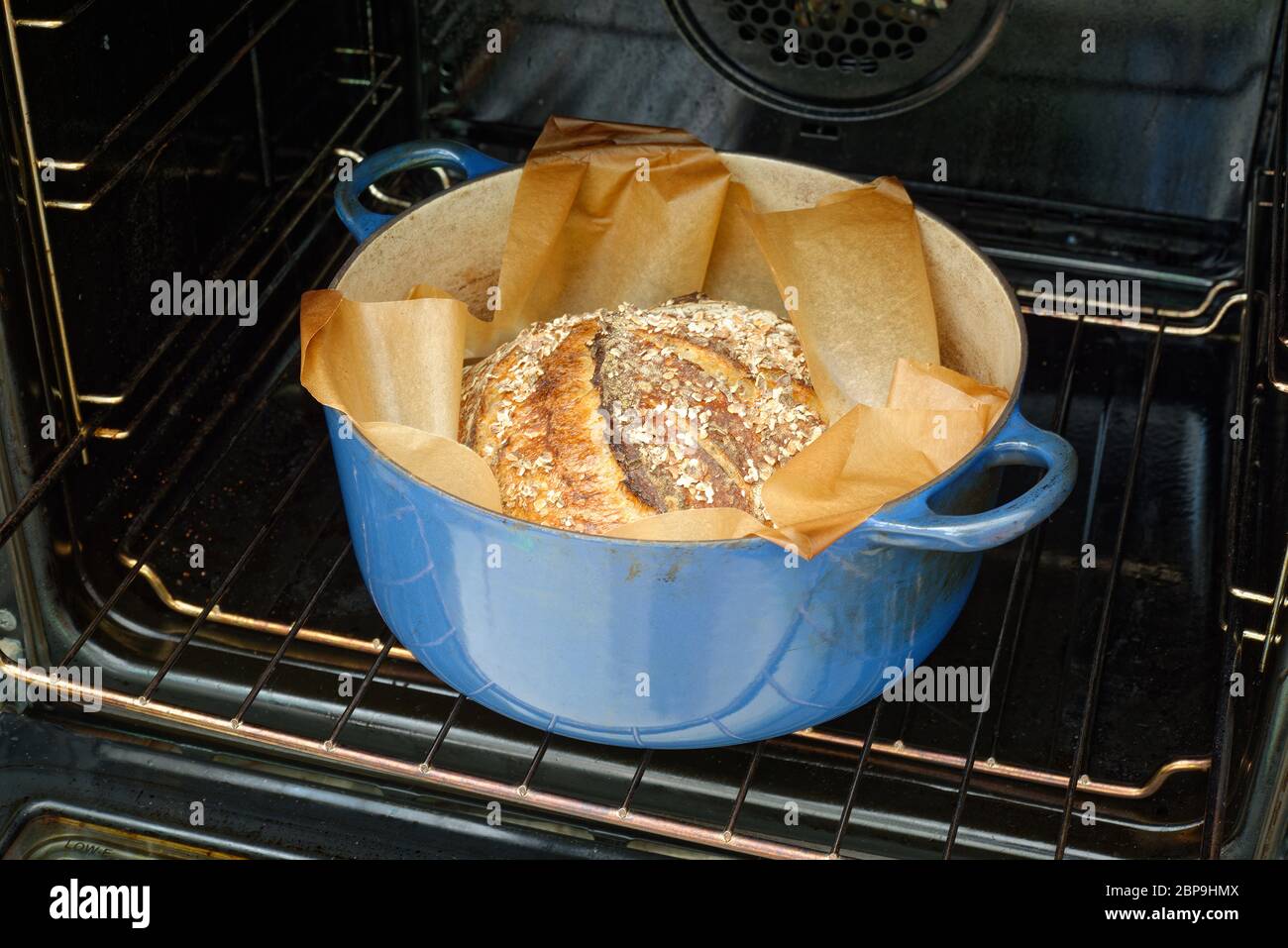 Pane fatto in casa. Pane di pasta di farina mentre il forno è aperto. Foto Stock