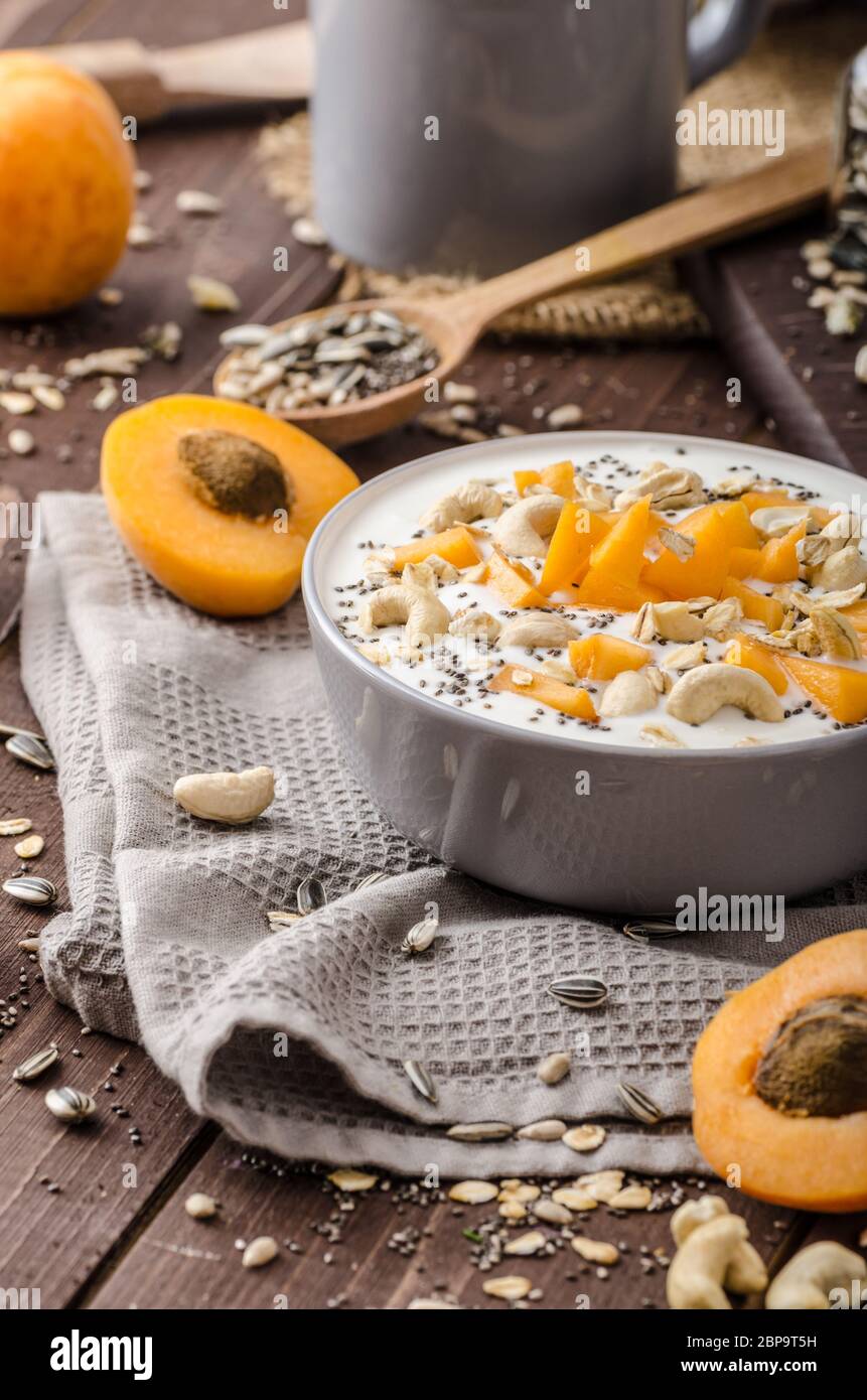 Albicocche domestico musli yogurt con il latte e croccante di dadi e sementi sane chia Foto Stock