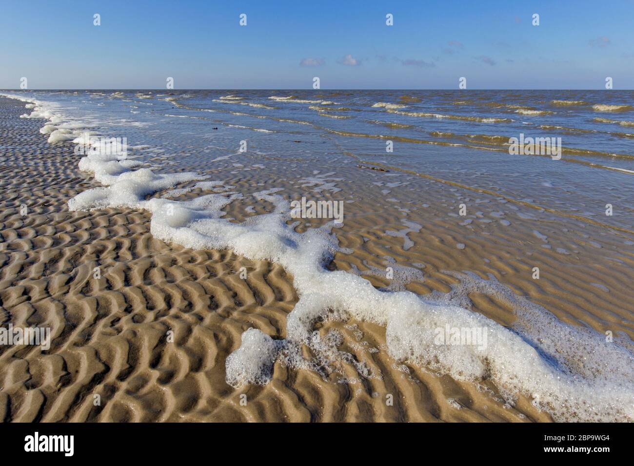 Schiuma su increspature di sabbia sulla spiaggia sabbiosa, Wadden Sea National Park, Schleswig-Holstein, Germania Foto Stock