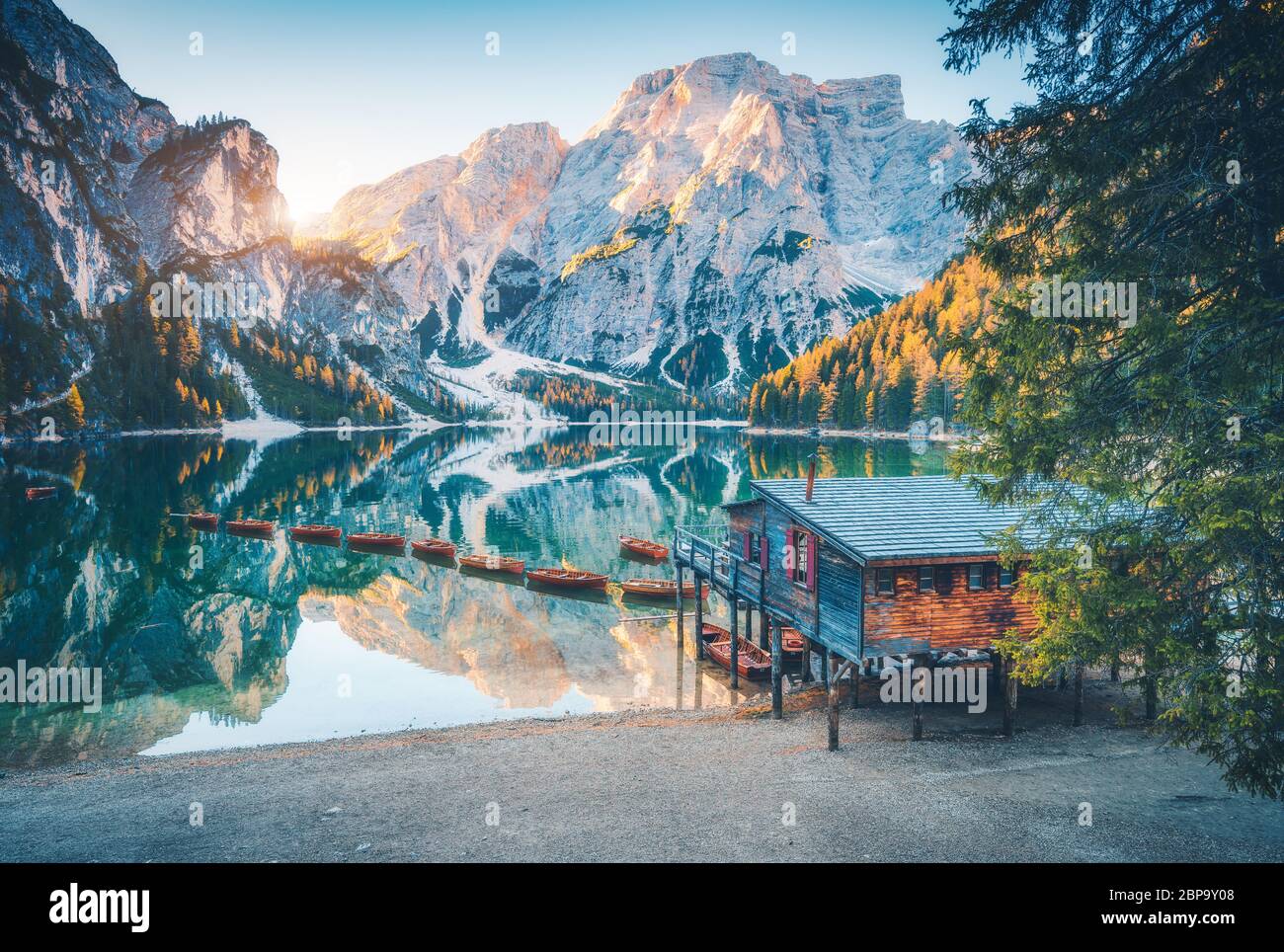 Barche e casa di legno sull'acqua sulla costa del lago di Braies Foto Stock