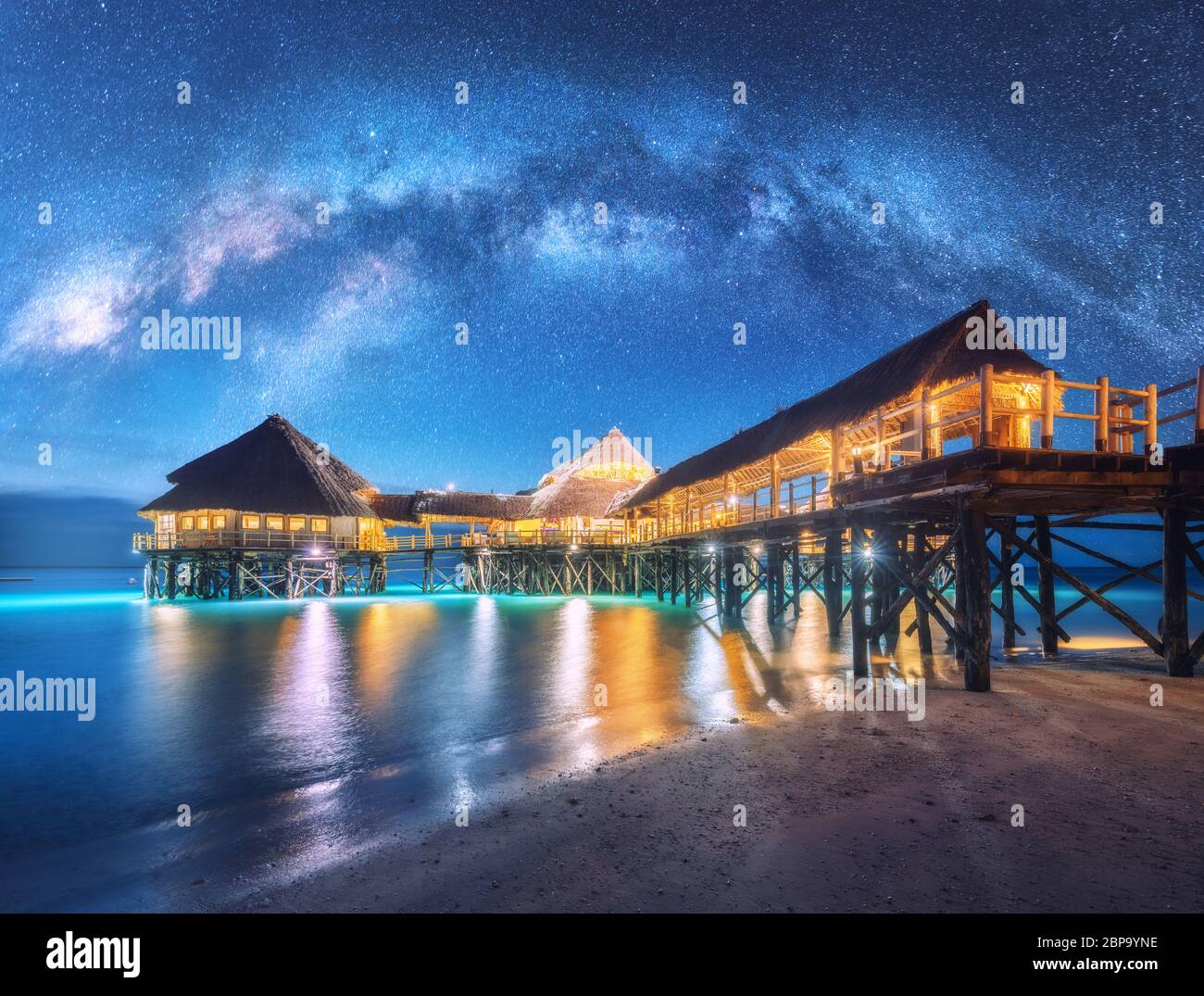 Milky Way e bungalow in legno sull'acqua in estate stellata notte Foto Stock