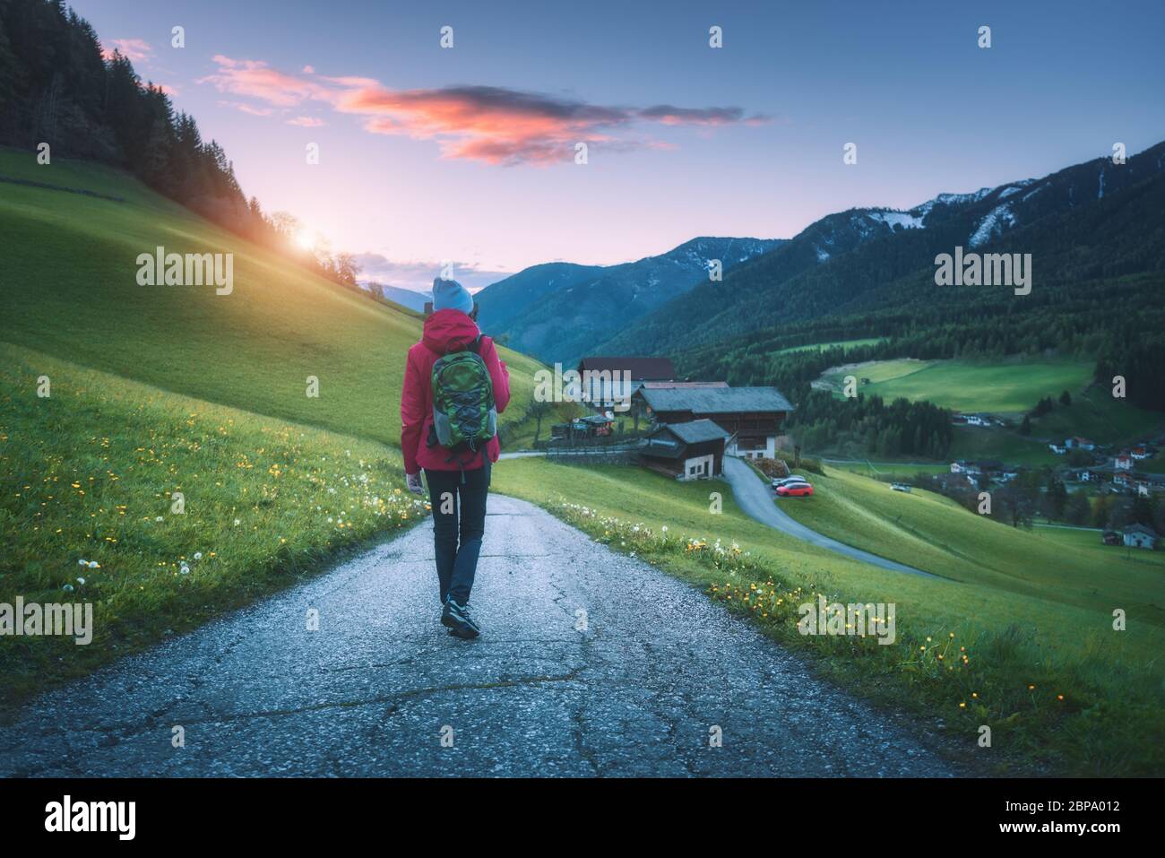 Giovane donna con zaino è in piedi sulla strada di montagna Foto Stock