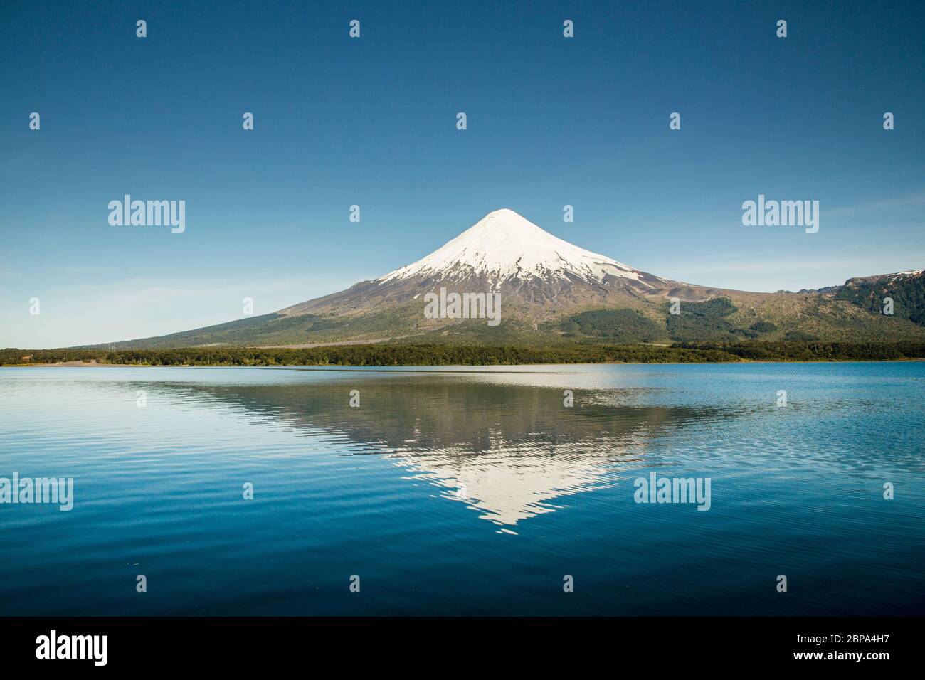 Il Volcan Osorno innevato si riflette nelle acque calme del Lago Todos Los Santos, vicino a Puerto Varas, Los Lagos Regione, Cile Foto Stock
