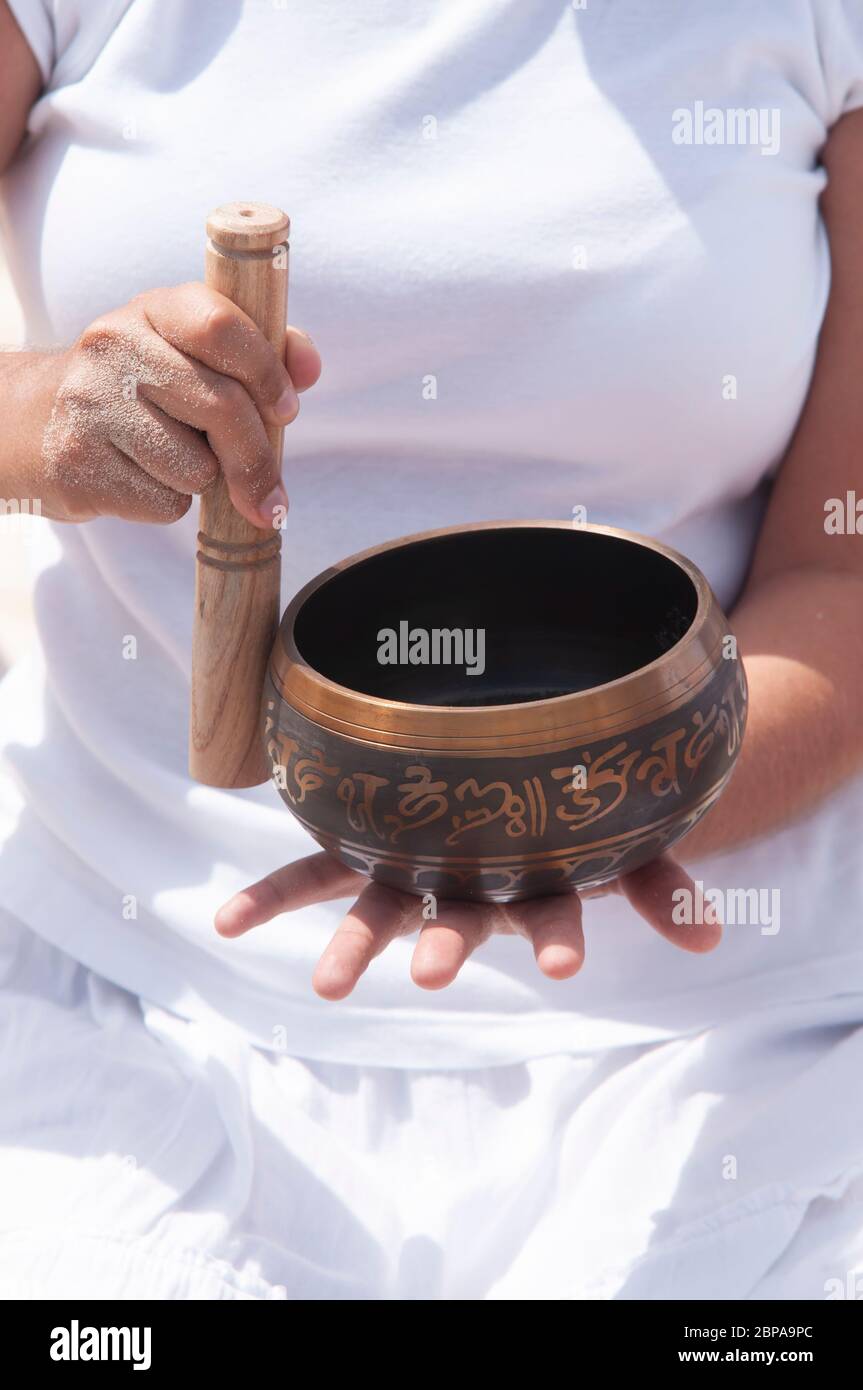 Una giovane donna gioca una bocce tibetana sulla spiaggia, Messico Foto Stock