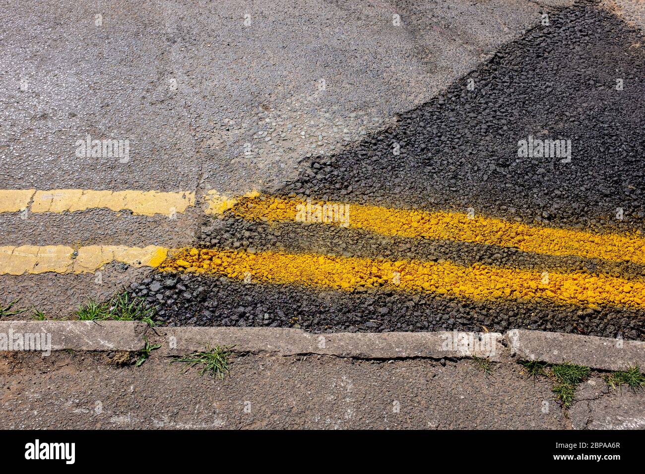 Professional restaurato linee doppie gialle dopo lavori stradali UK Foto Stock