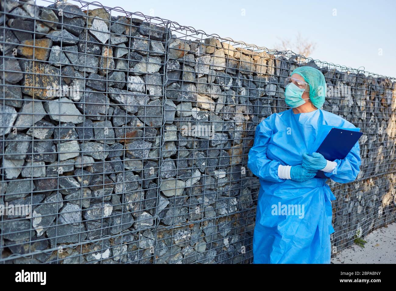 Il personale infermieristico o lo scout di contenimento attende di fronte al muro i visitatori con lista per il monitoraggio dei contatti nella pandemia di coronavirus Foto Stock