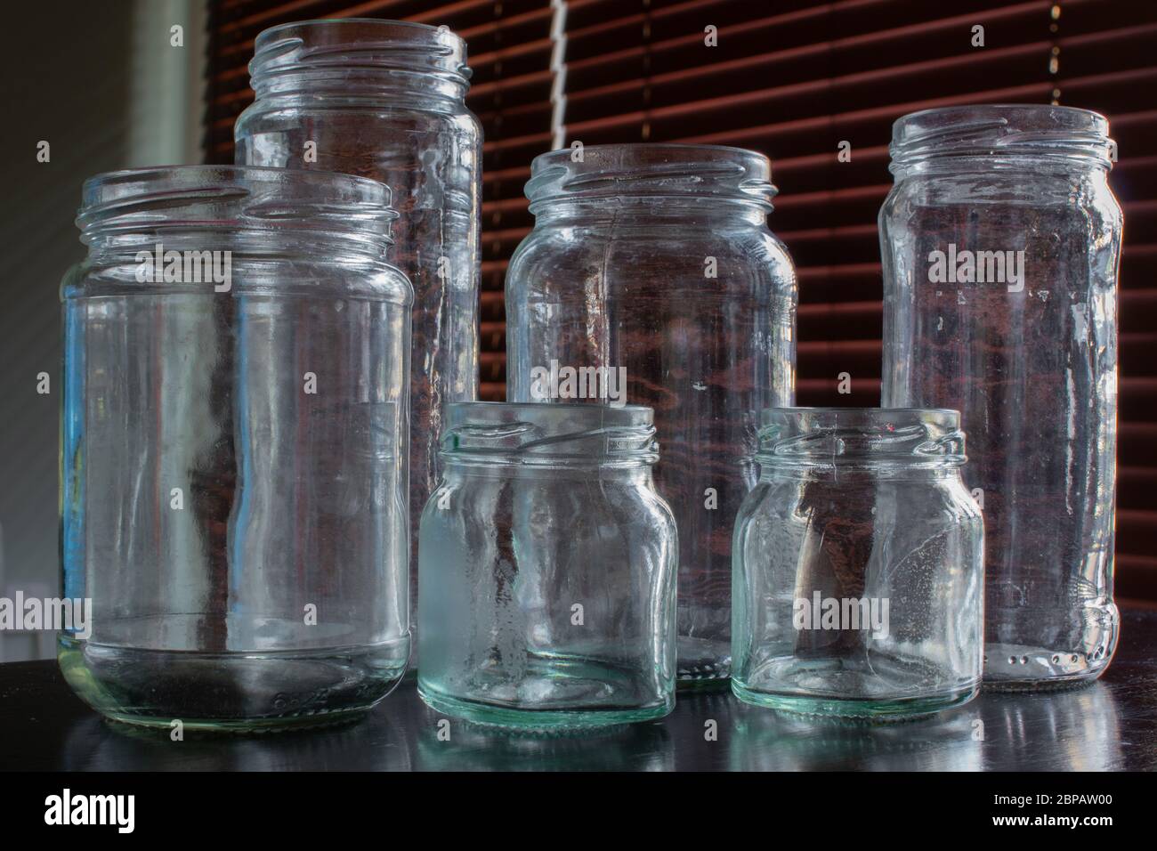 Sei vasetti di vetro vuoti, usati e leggermente sporchi. Foto Stock