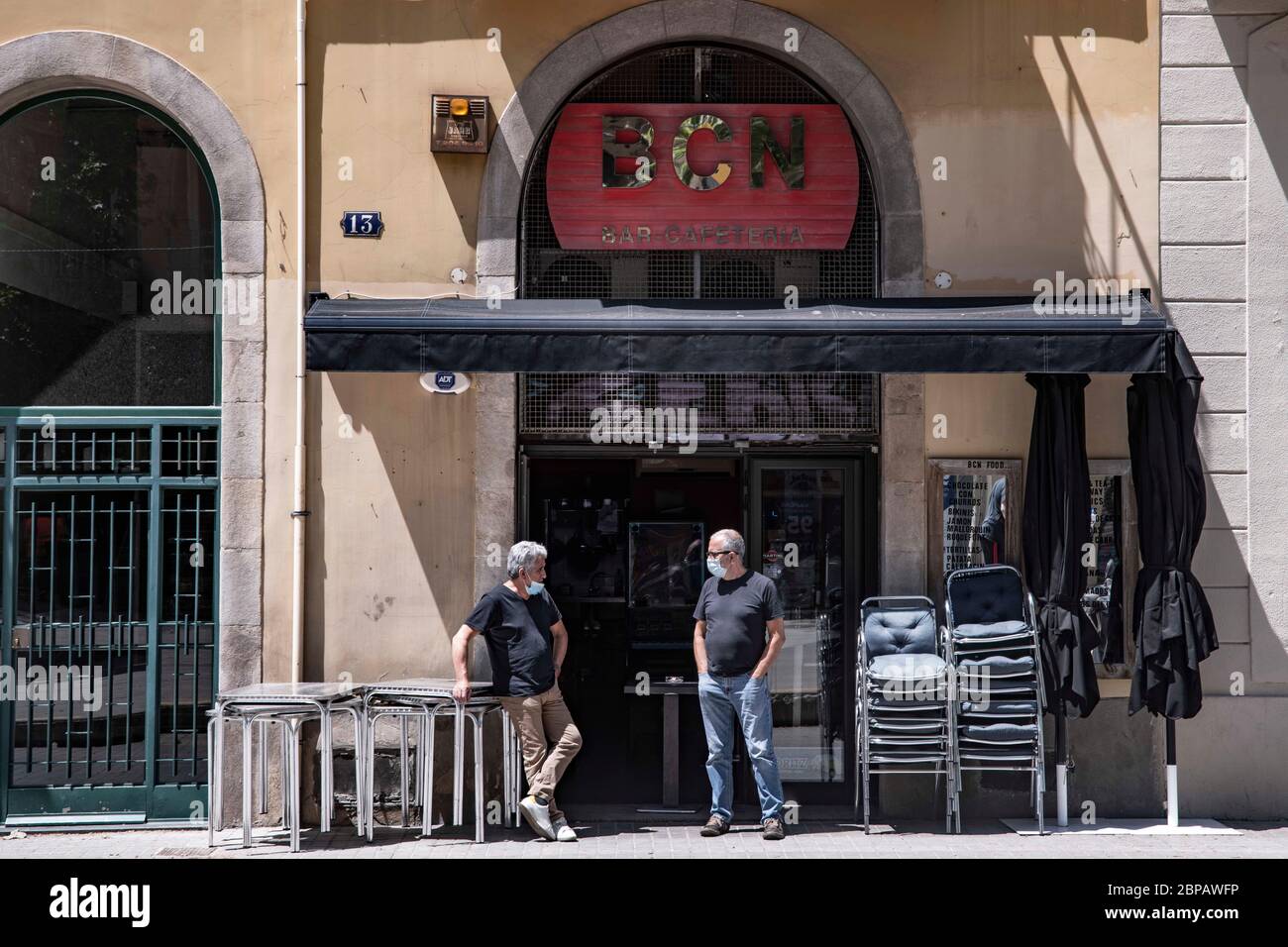 Due persone hanno un colloquio alla porta di un ristorante chiuso a Barcellona, Spagna il 13 maggio 2020. La città continua a rimanere allo stadio zero di graduale decompressione delle restrizioni di confinamento. In questo caso, i negozi devono essere chiusi al pubblico, con l'unica eccezione di fissare un appuntamento in anticipo e i ristoranti possono solo effettuare ordini di decollo. Nel frattempo, in altre aree del paese è stata attivata la fase 1. La Spagna si trova a fronteggiare il 64° giorno di stato di emergenza a causa della pandemia di Coronavirus. (Foto di Carmen Molina/Sipa USA) Foto Stock