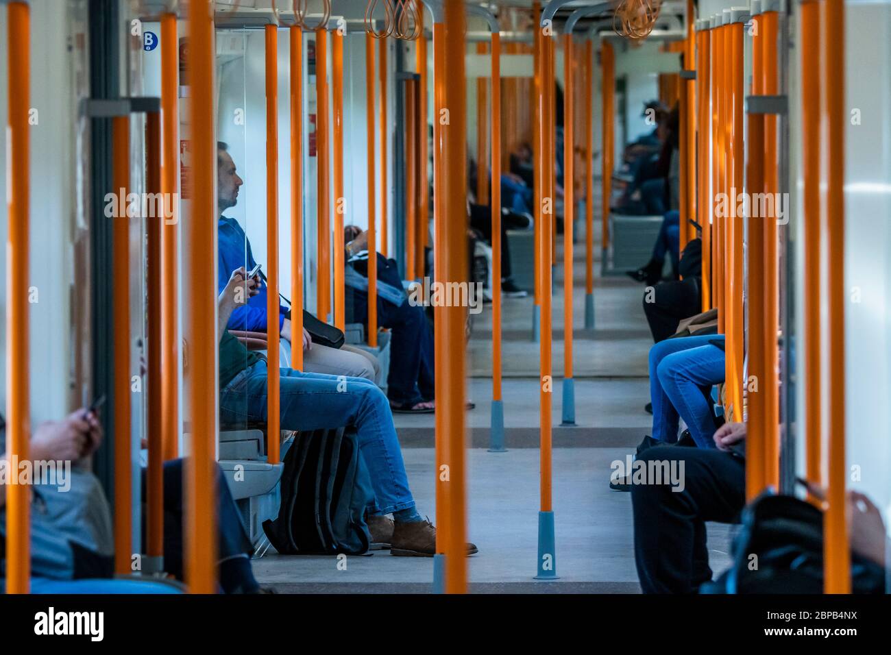 Londra, Regno Unito. 18 maggio 2020. Il terreno ha alcuni passengers con abbondanza di spazio per la distanza sociale, poche maschere di usura - sistemi di senso unico e personale supplementare per guidare la spola, ma i treni sono in gran parte vuoti, anche alle ore di punta. Il "blocco" dei morti continua per l'epidemia di Coronavirus (Covid 19) a Londra. Credit: Guy Bell/Alamy Live News Foto Stock