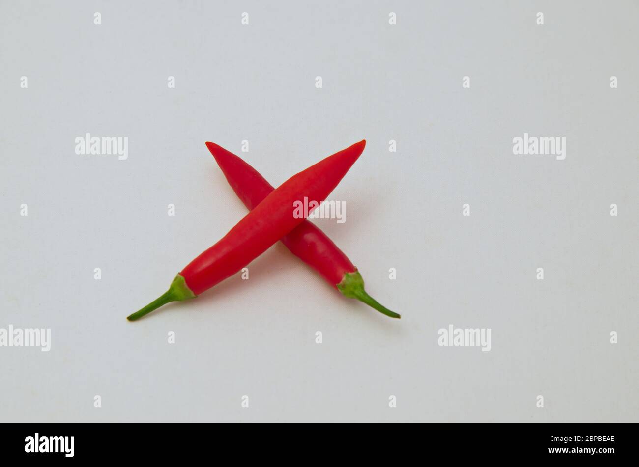 Moltiplicazione segno o simbolo, fatta con il frutto del peperoncino fresco con un gambo verde, Sofia, Bulgaria Foto Stock