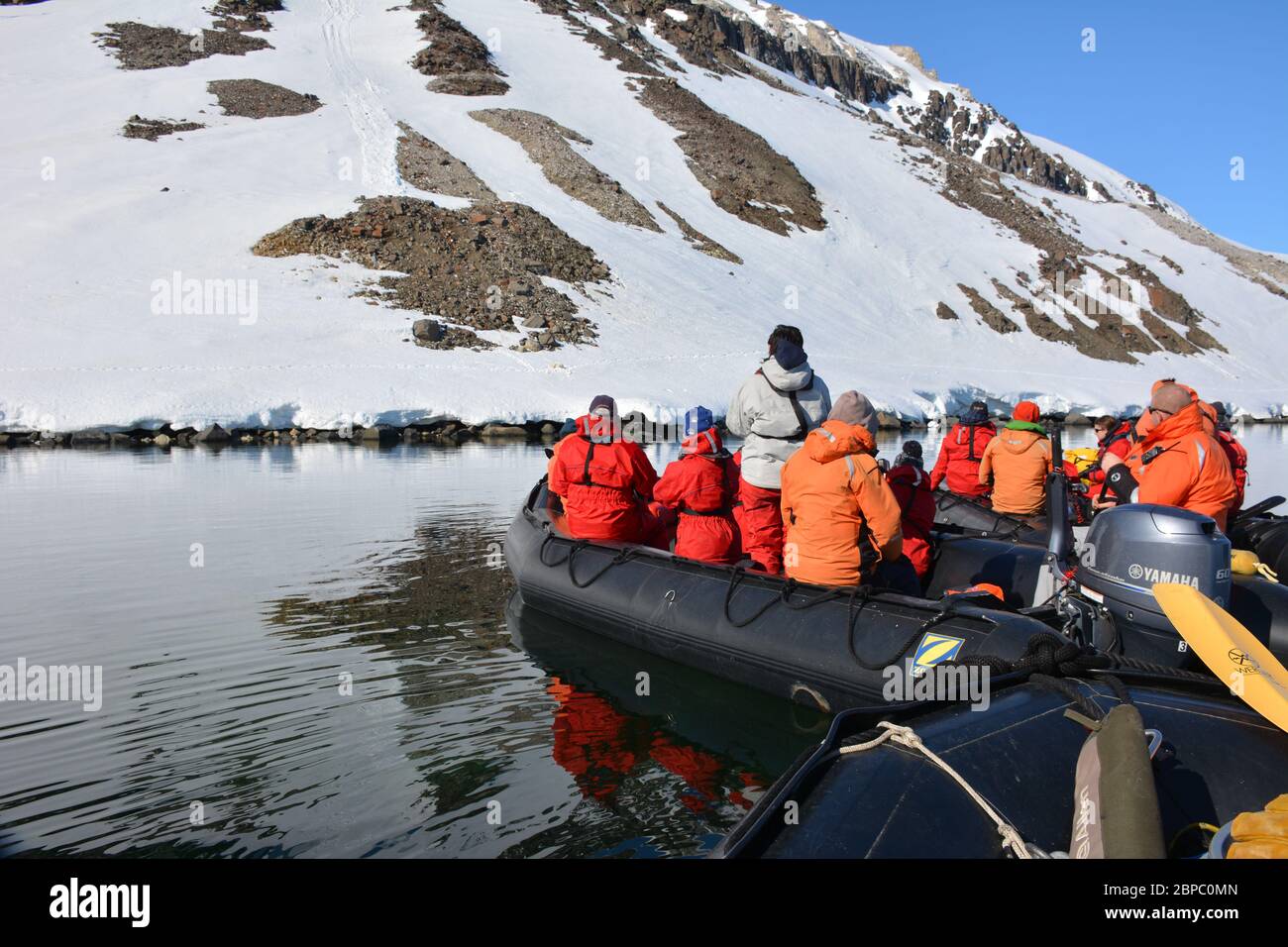 I turisti in uno zodiaco guardano un orso polare femminile e il suo cucciolo nello stretto di Hinlopen, Svalbard. Foto Stock