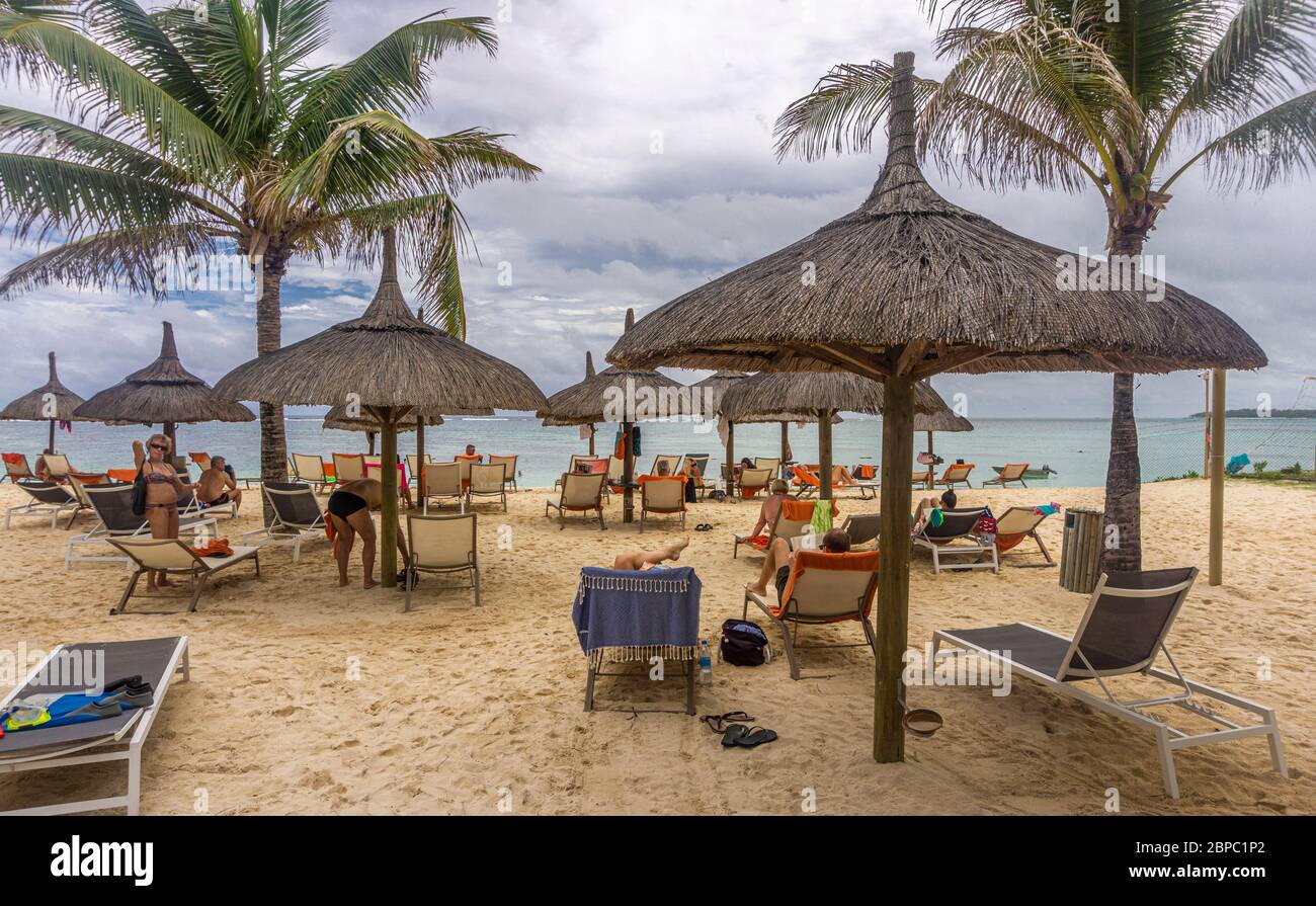 Capanne di paglia e sedie relax sulla spiaggia di un resort tropicale nell'isola di Mauritius Foto Stock