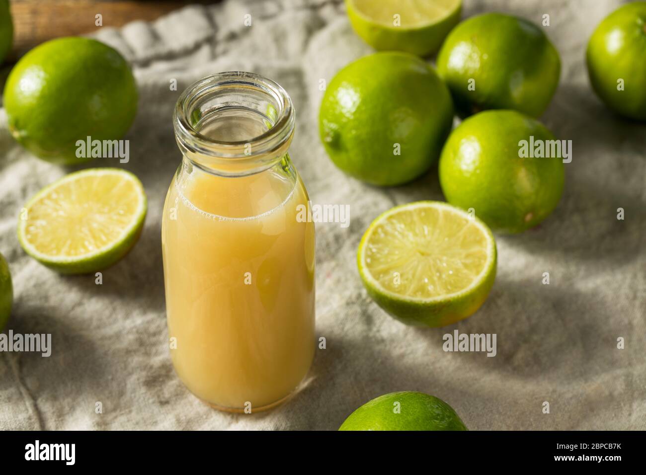 Succo di lime fresco e organico grezzo pronto all'uso Foto Stock