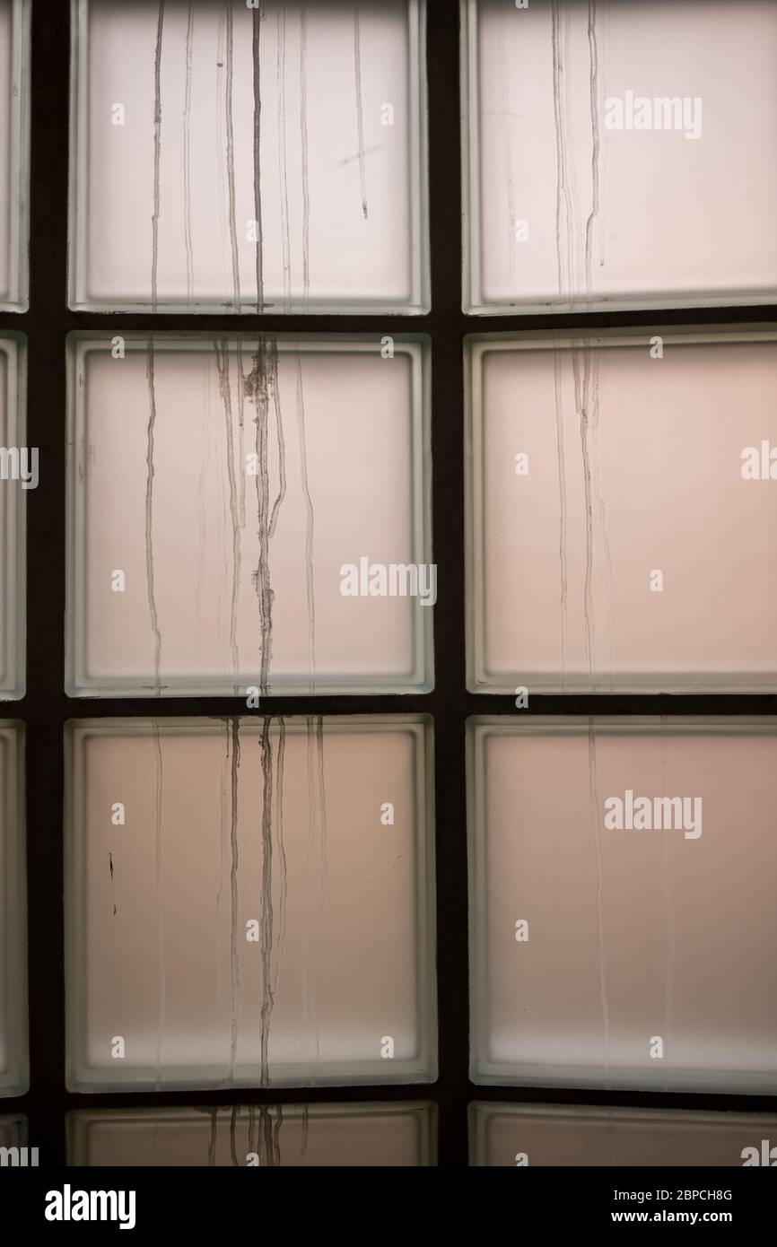 Interno dell'edificio che guarda ad una finestra opaca costruita con blocchi di vetro Foto Stock