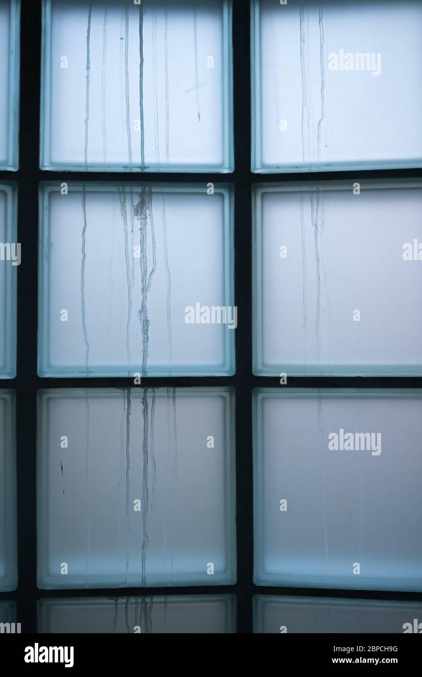 Interno dell'edificio che guarda ad una finestra opaca costruita con blocchi di vetro Foto Stock