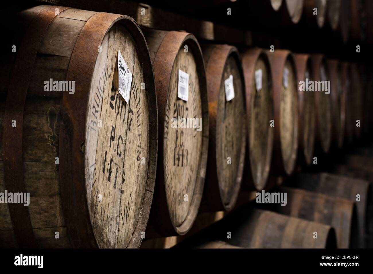 Barili di whisky in legame sull'isola di Islay Foto Stock