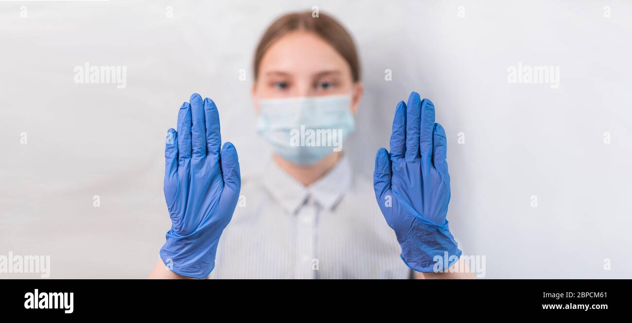 primo piano fuoco guanti adolescente ragazza maschera medica, stop gesto con le mani stop, attenzione, pericoloso, fotocamera. Aiuta a rallentare l'epidemia di corona virus Foto Stock