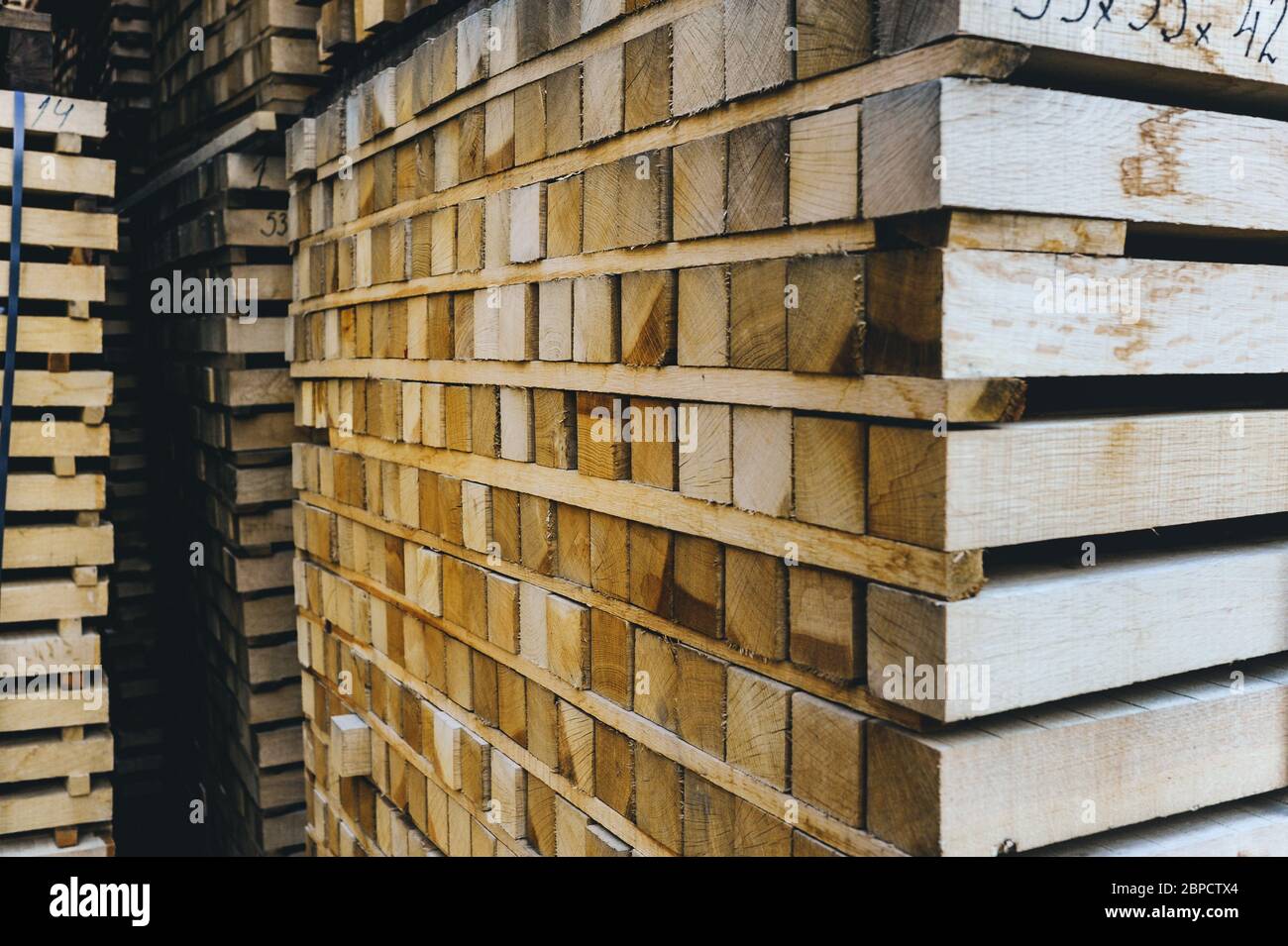 Pila di barre di legno. Estremità quadrate delle barre di legno. Legno legno materiale per costruzione per sfondo e struttura. Primo piano. Foto Stock