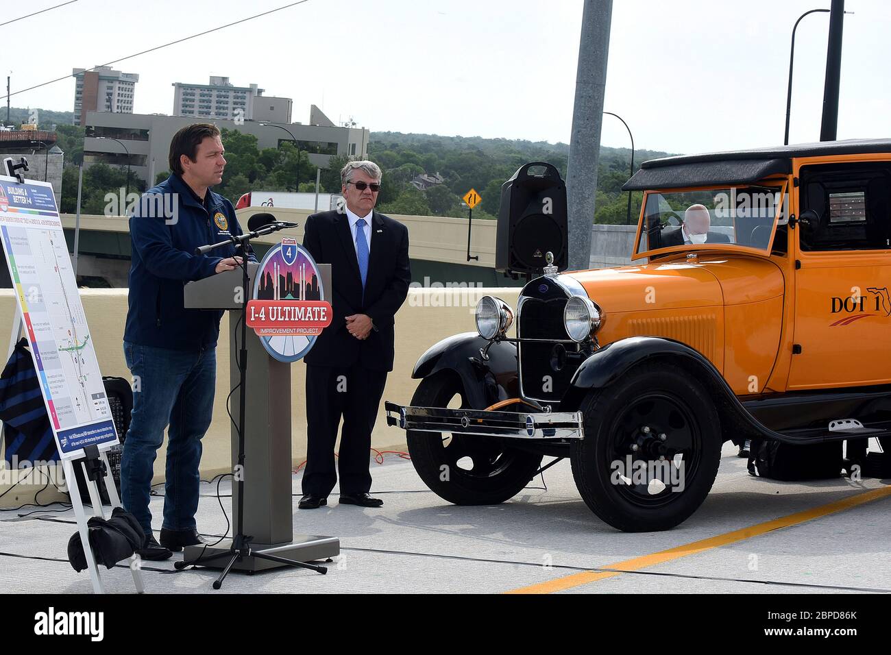 18 maggio 2020 - Orlando, Florida, Stati Uniti - Florida Gov. Ron DeSantis parla ad una conferenza stampa il 18 maggio 2020 al recentemente completato i-4 e state Road 408 interscambio che si apre al traffico stasera nel centro di Orlando, Florida. DeSantis ha spiegato che i progressi sul 21-Mile i-4 Ultimate Project sono stati accelerati alla sua direzione a causa della diminuzione del traffico durante la crisi del coronavirus. A destra è il Segretario del Dipartimento dei Trasporti della Florida Kevin Thibault e il reparto restaurato 1929 modello AA Ford camion, soprannominato DOT 1. (Paul Hennessy/Alamy) Foto Stock