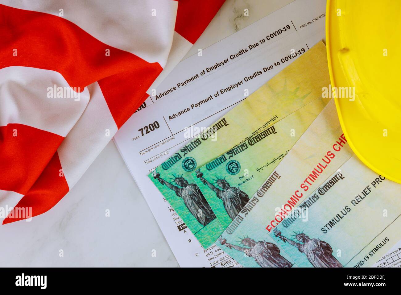 Bandiera americana su Stimulus assegno di soccorso finanziario al passaporto degli Stati Uniti in elmetto giallo Foto Stock