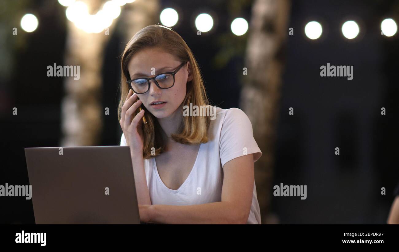 ?ipster ragazza in conversazione casuale via telefono mobile e facendo freela Foto Stock