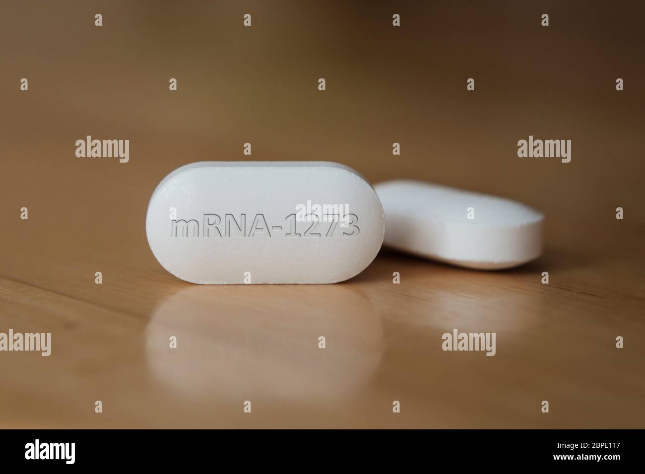 MRNA-1273 pillola sul tavolo. Foto concettuale. Illustrativa per il potenziale farmaco di trattamento COVID-19. Messa a fuoco selettiva, profondità di campo poco profonda. Foto Stock