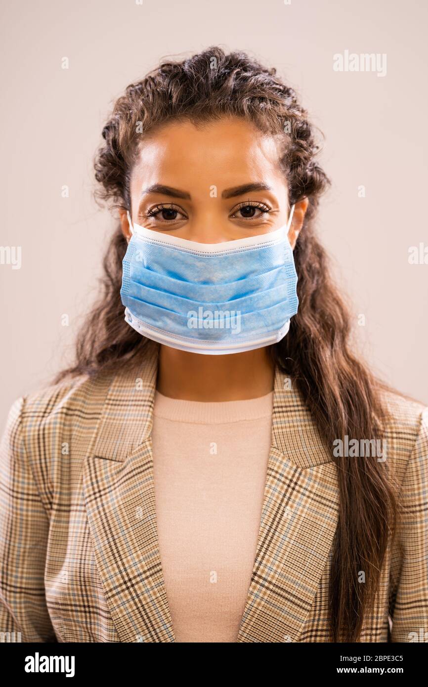 Studio ritratto di bella etnia afroamericana uomo d'affari con maschera protettiva. Foto Stock