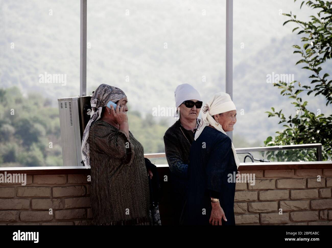 Almaty, Kazakhstan - 3 settembre 2019: Tre donne anziane riposano su un punto di vista in Almaty mentre una di loro sta usando il suo telefono cellulare. Foto Stock