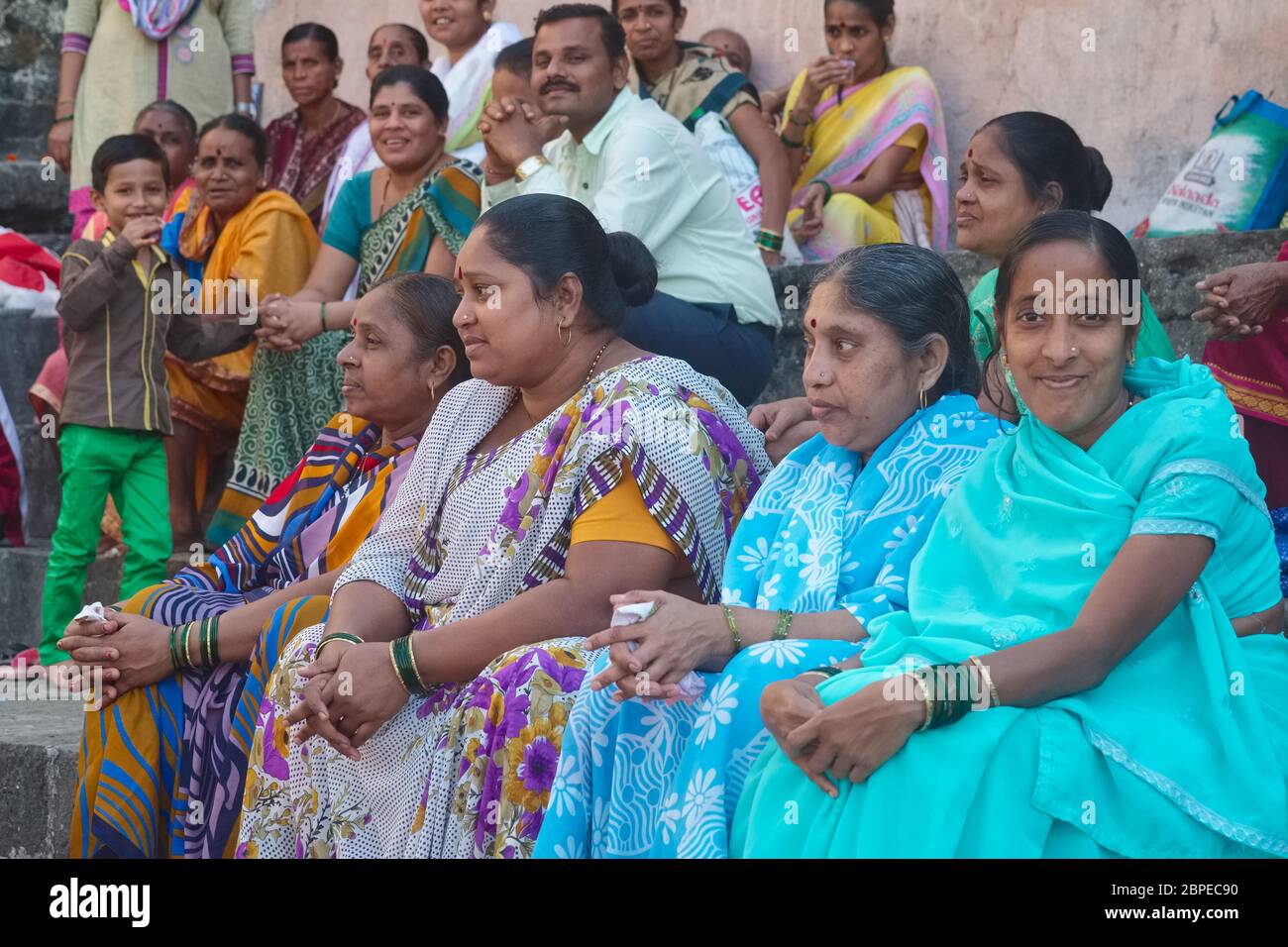Membri allegri di una famiglia indiana estesa, per lo più donne e pochi uomini, in una visita al sito sacro (indù) Banganga Tank a Walkeshwar, Mumbai, India Foto Stock