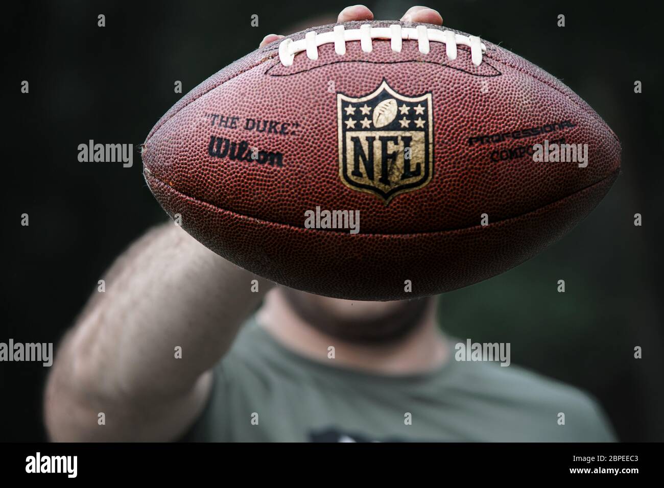L'uomo tiene la palla NFL. Foto Stock