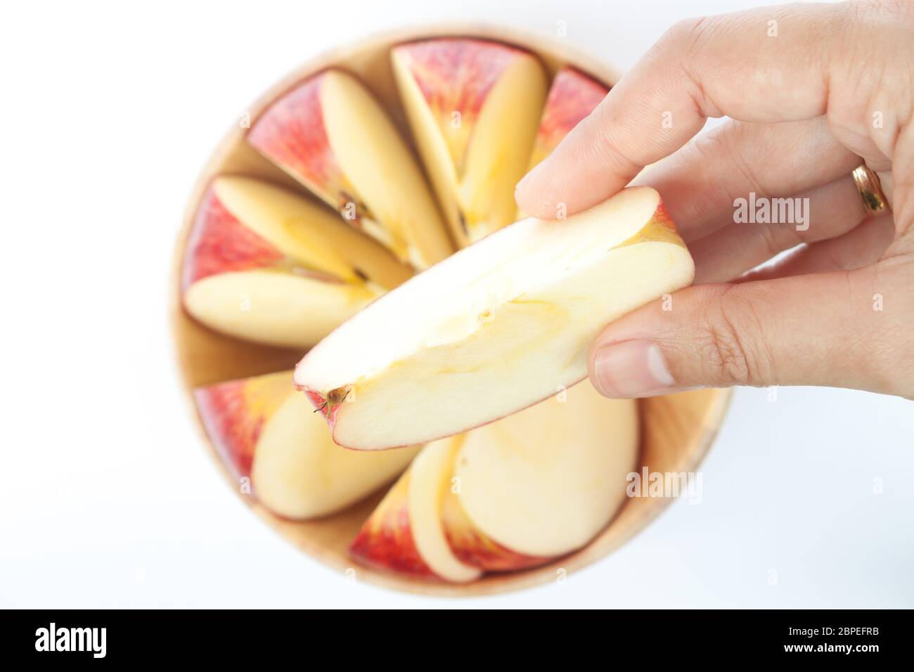 Donna mano azienda pezzo di Apple su sfondo bianco Foto Stock