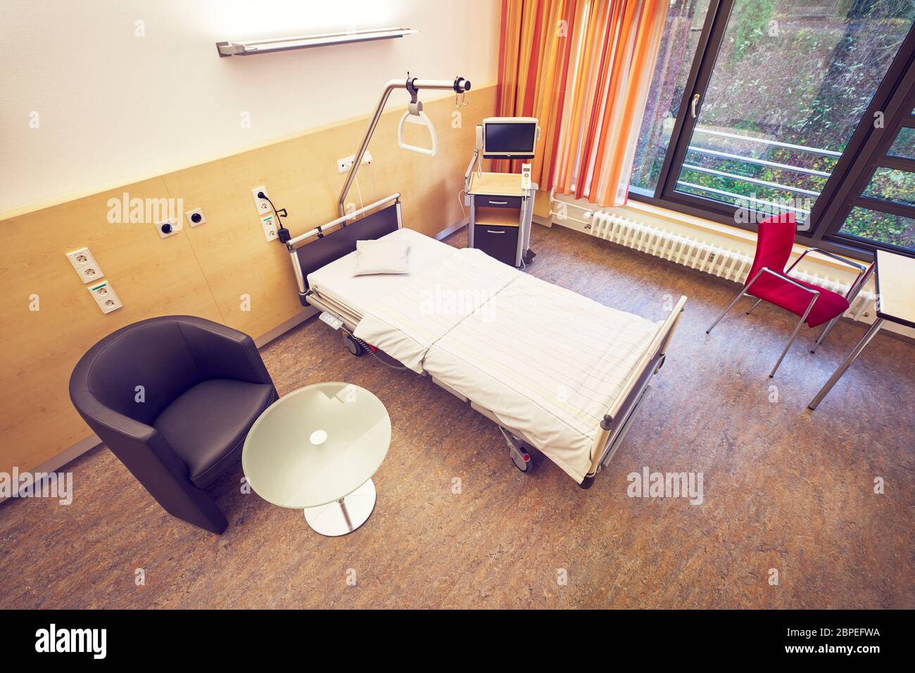 Leeres Zimmer mit Bett Tisch und Stuhl im Krankenhaus auf der Privatstation von oben aus der Vogelperspektive Foto Stock