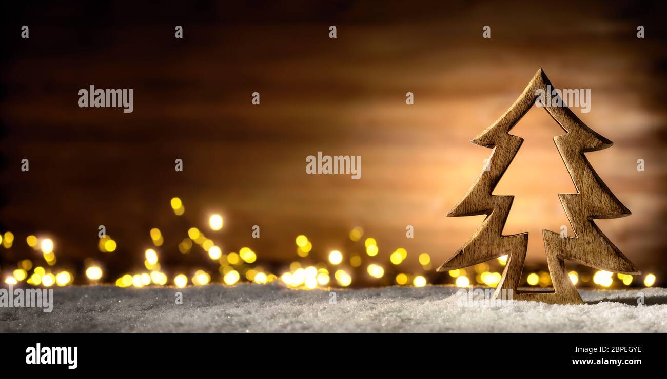 Accogliente disposizione di Natale con bellissimi ornamenti di legno sulla neve nel caldo lume di candela di una bella lanterna, basso-chiave studio shot Foto Stock