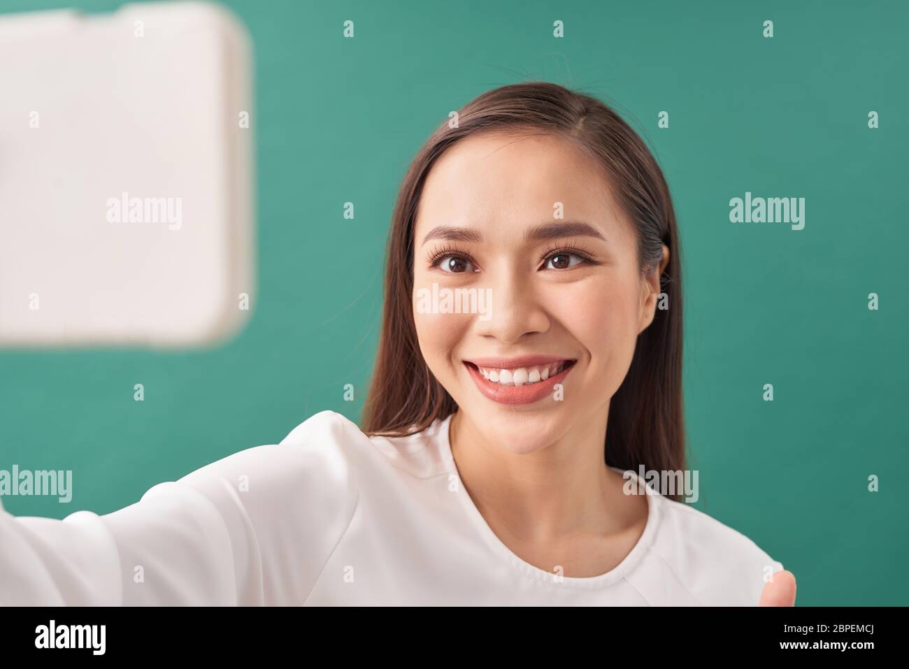 Signora di buon umore con il sorriso espansivo godendo i fine settimana cominciati e prendendo selfie sul telefono mobile Foto Stock