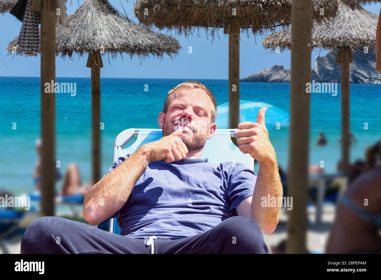 Strandleben, Urlauber am Strand. Focus auf Mann Liegestuhl im. Hintergrund gewünschte unschärfe. Foto Stock