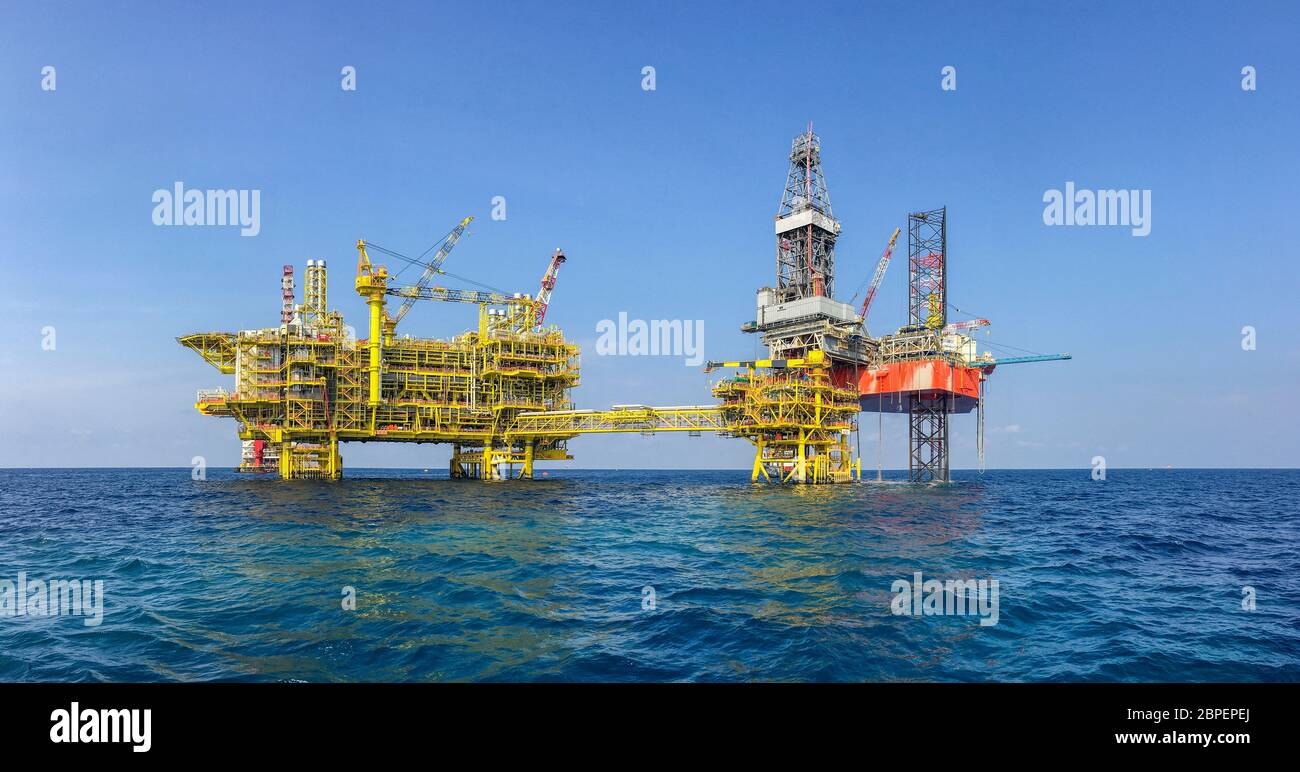 Industria petrolifera e del gas. Panorama di carri di perforazione con  camicia rossa sulla piattaforma della