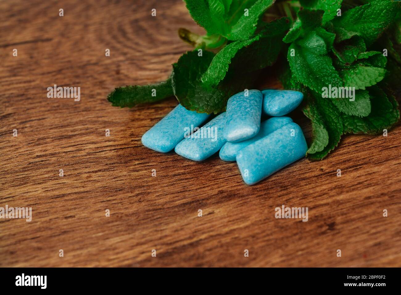 Le gomme da masticare e verde menta su uno sfondo di legno Foto Stock