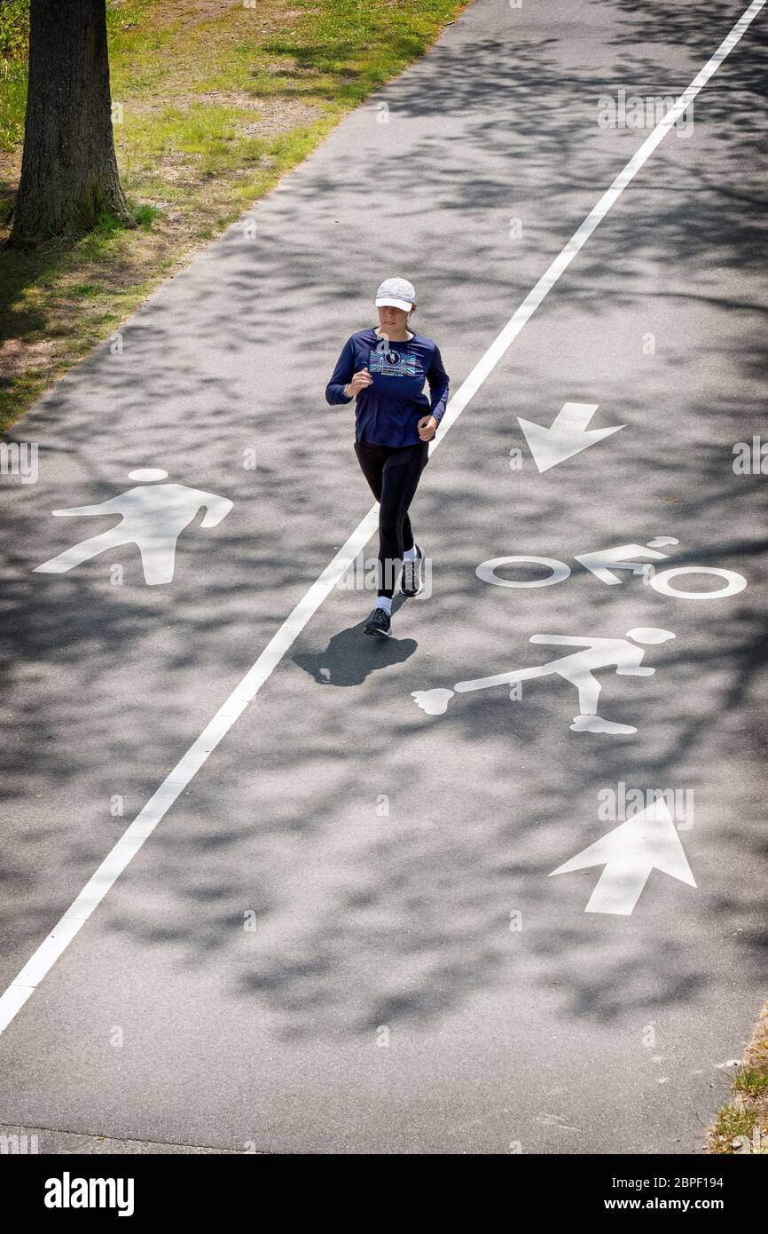 Una donna che corre su un sentiero vicino alla Marina di Bayside a Queens, New York City Foto Stock