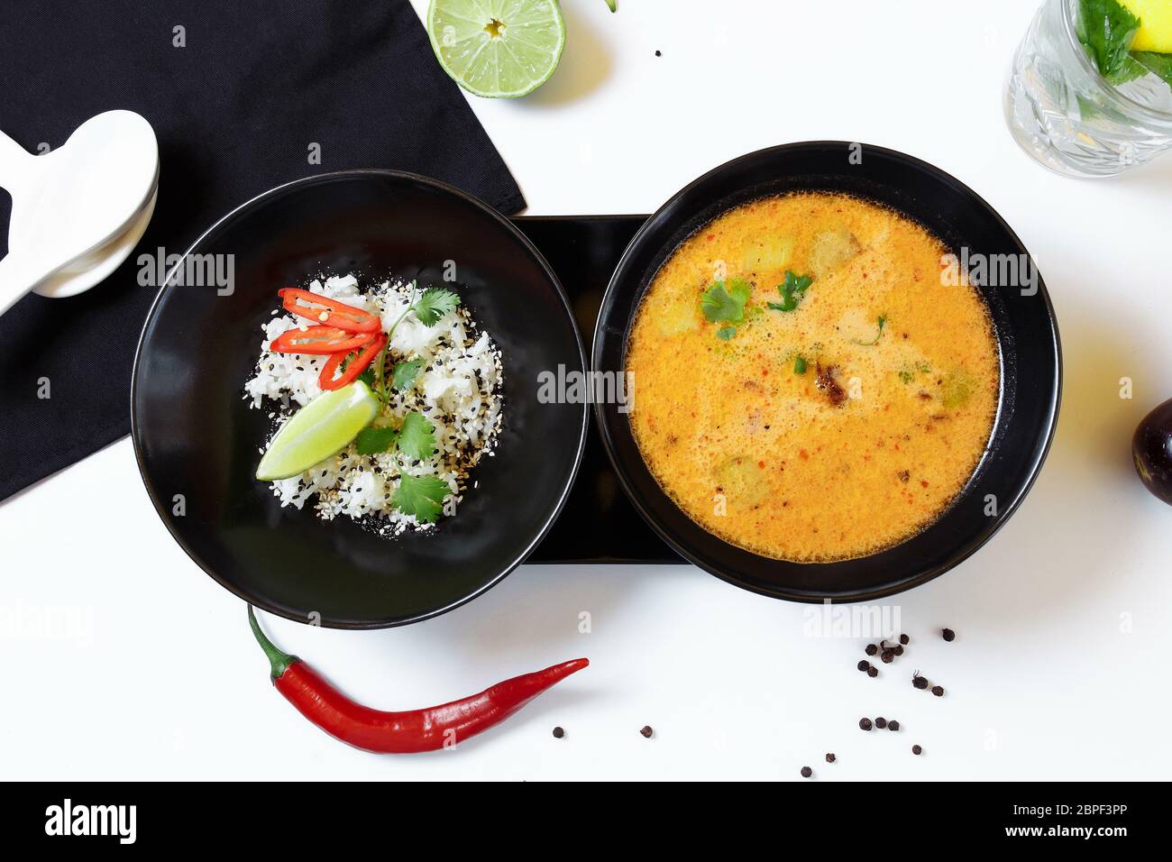 Tom Kha. Zuppa asiatica speziata con melanzane, pollo, funghi, citronella, servita con riso e coriandolo Foto Stock